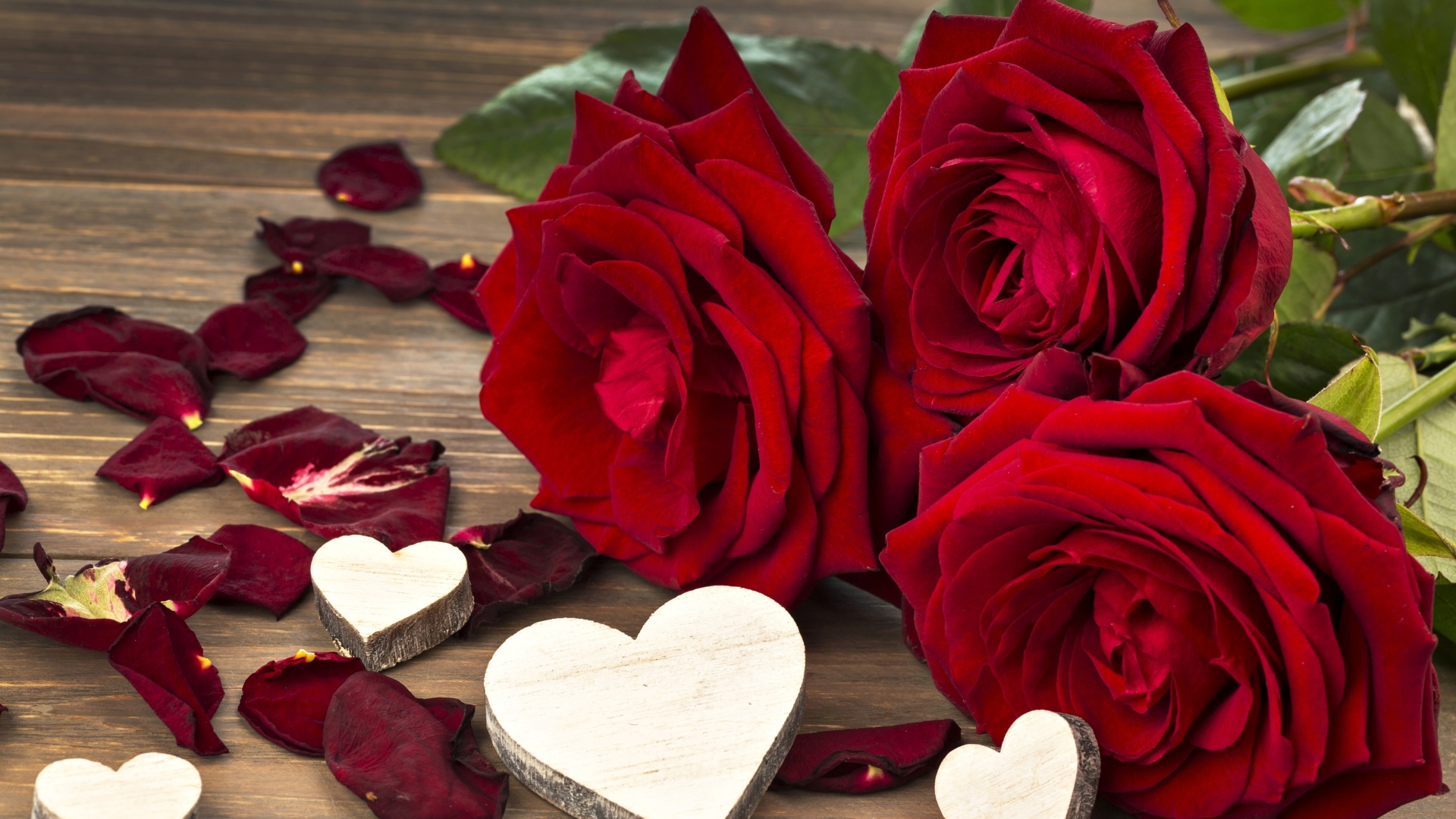 Три крупные красные розы с деревянными сердечками