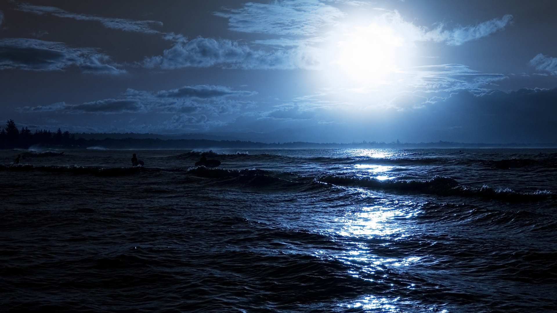 Яркая луна освещает волны на берегу моря