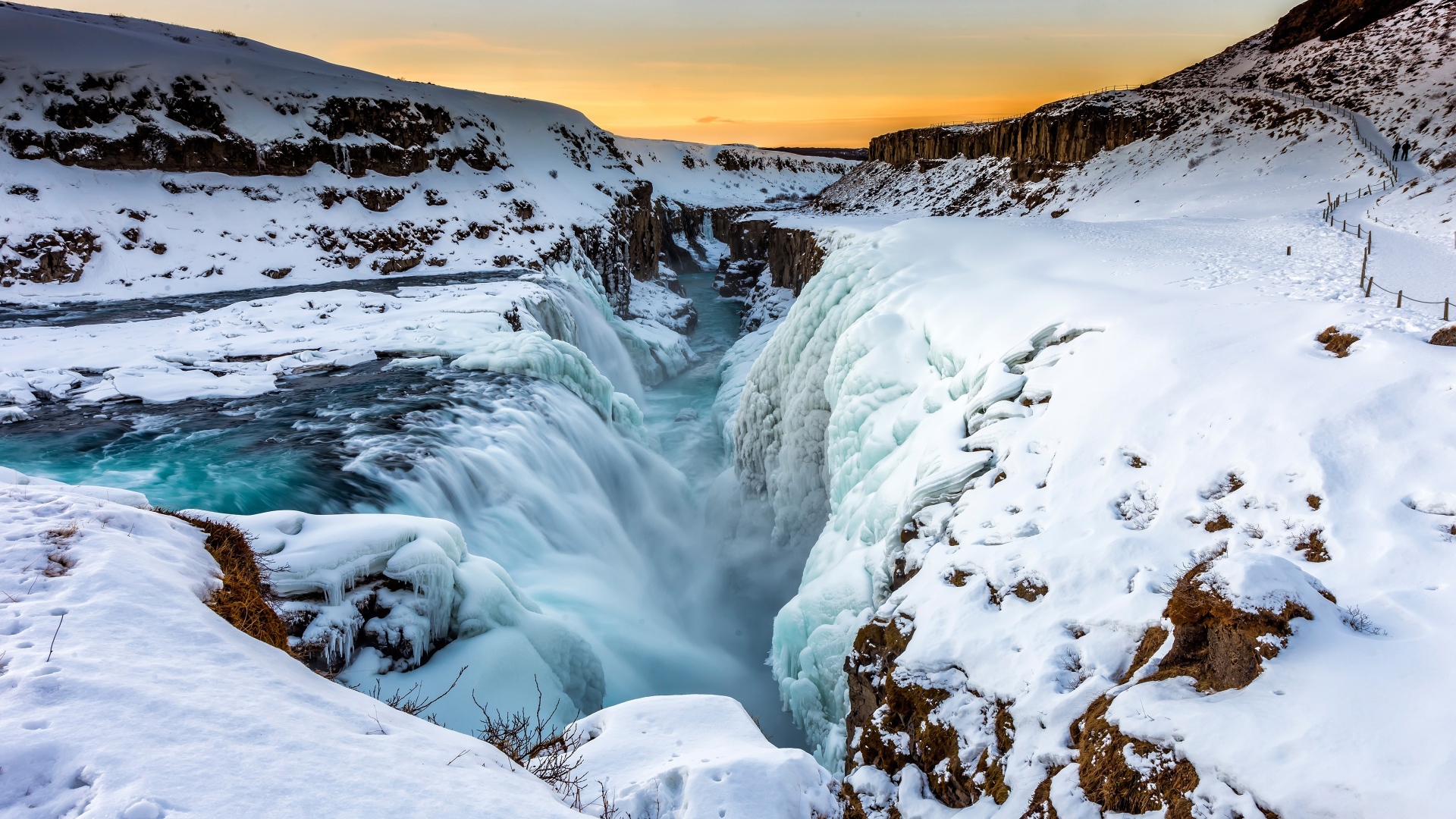 Заледеневший водопад у покрытых снегом берегов, Исландия
