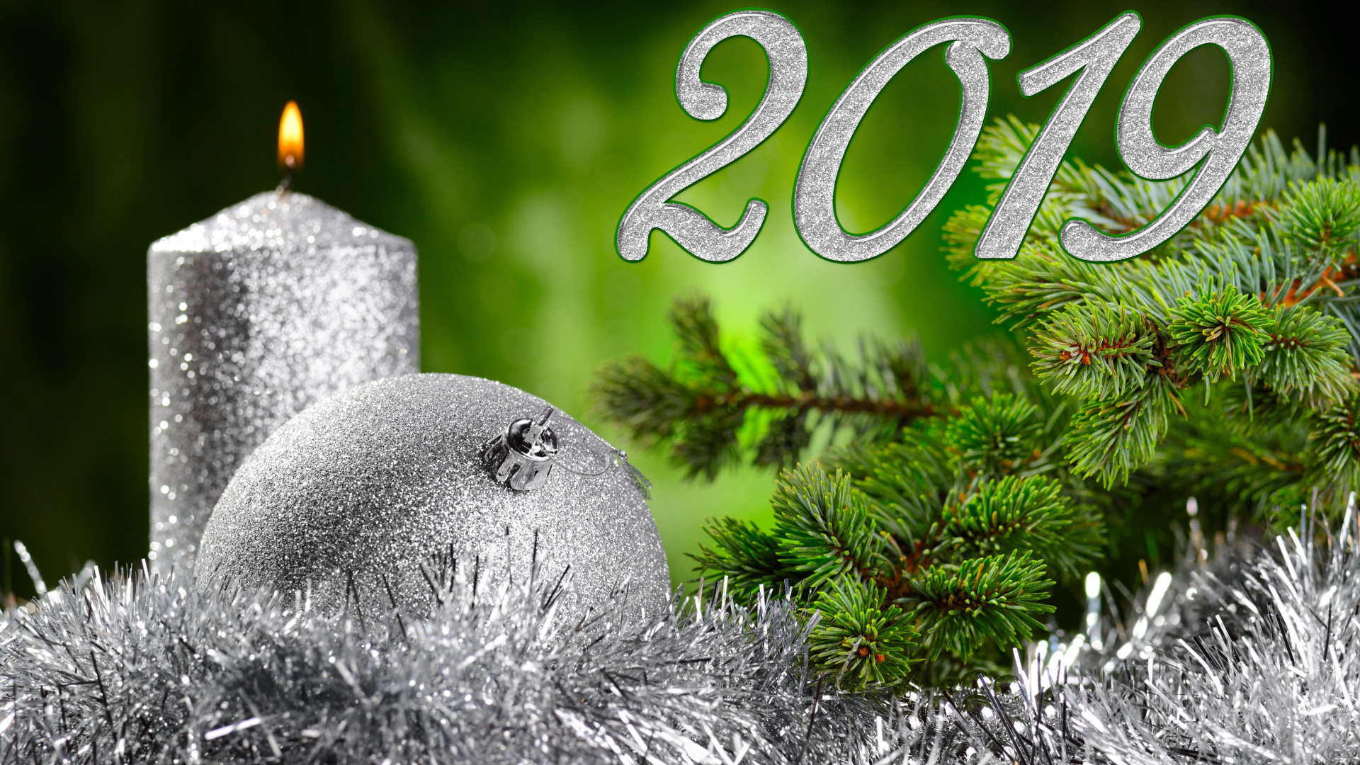 Красивый серебряный шар и свеча с еловой веткой на Новый год и Рождество 2019 