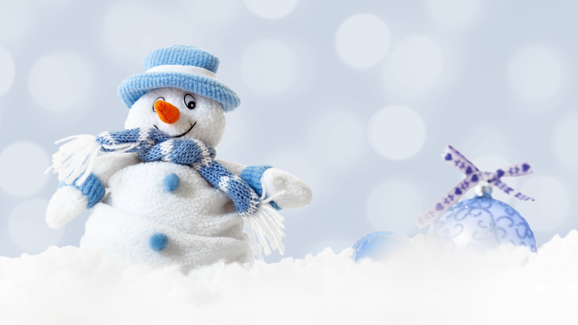 Игрушка снеговик и елочная игрушка на снегу 