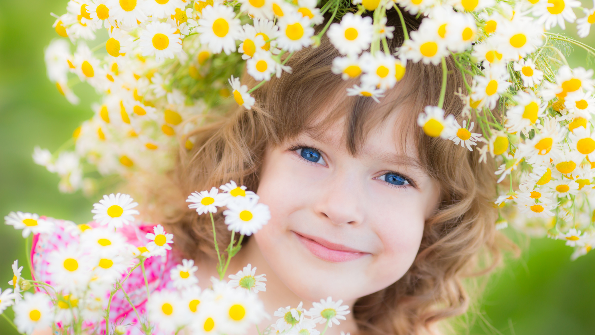 Маленькая девочка с венком из ромашек на голове