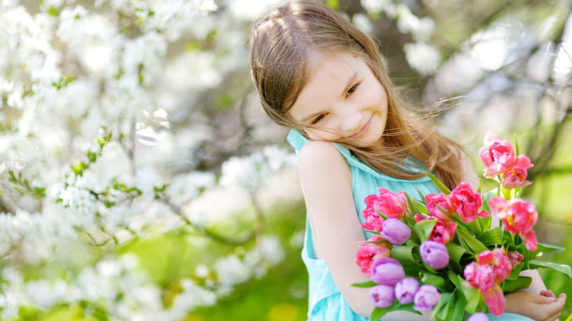 Красивая маленькая девочка с букетом тюльпанов весной