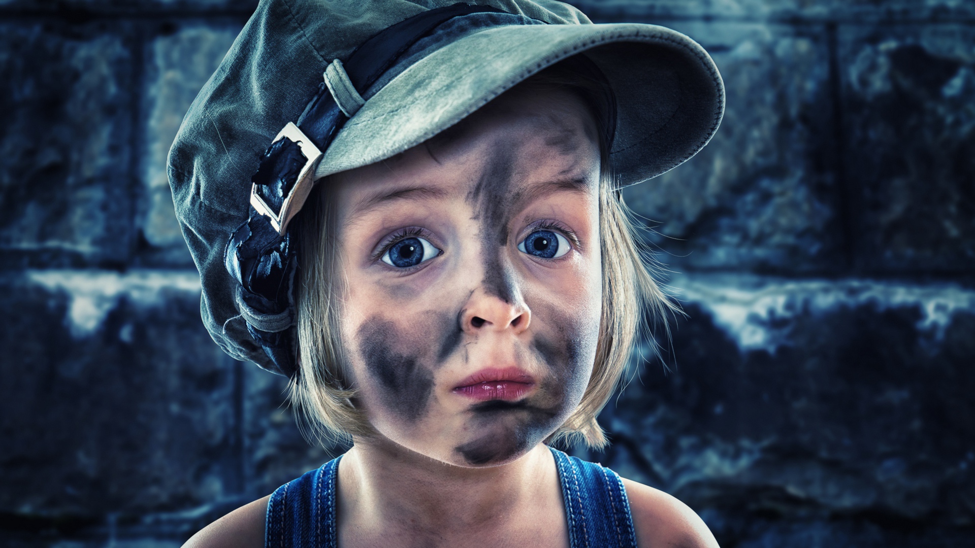 Смешная девочка в кепке с грязным лицом