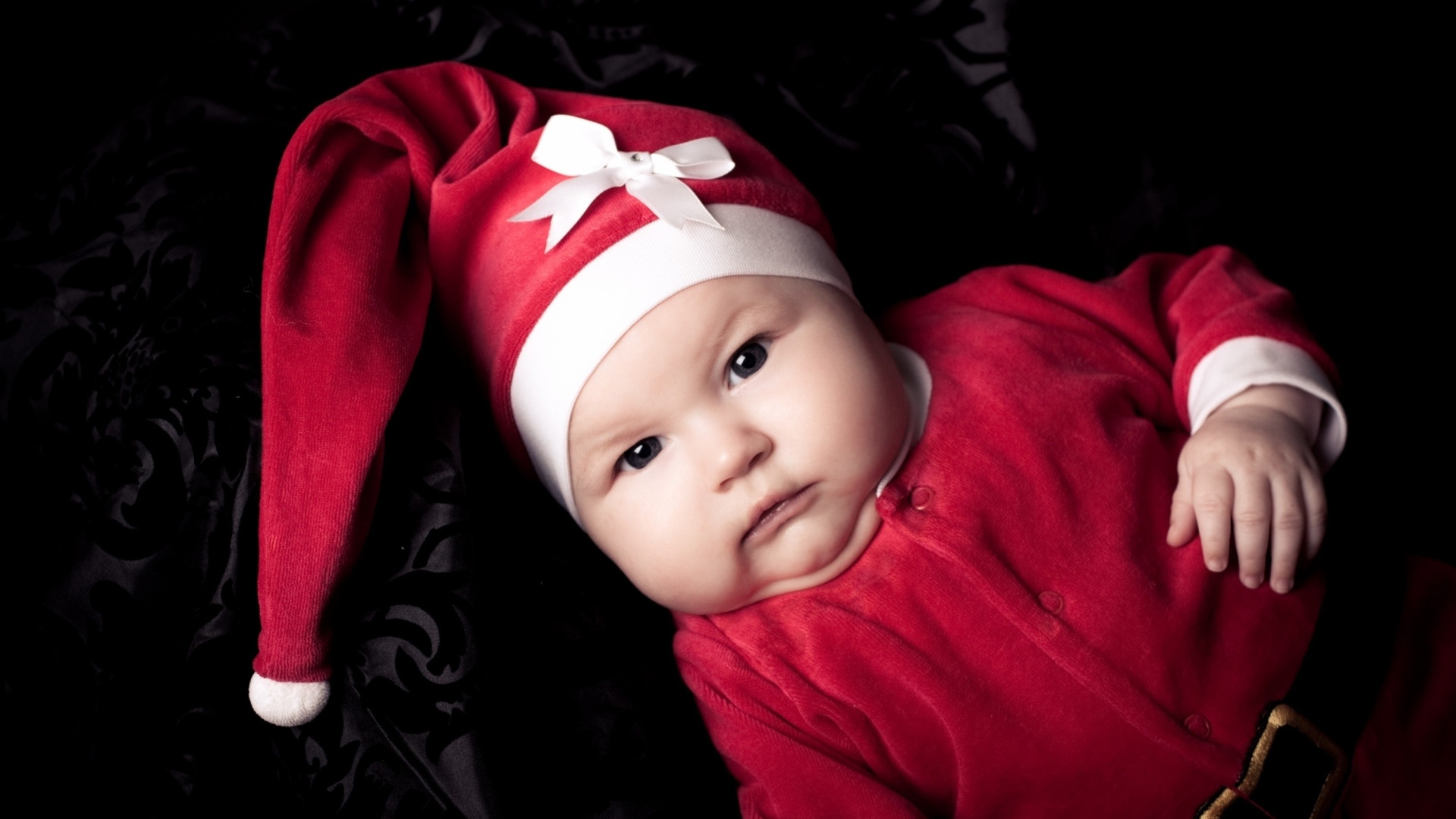 Грудной ребенок в красном новогоднем костюме