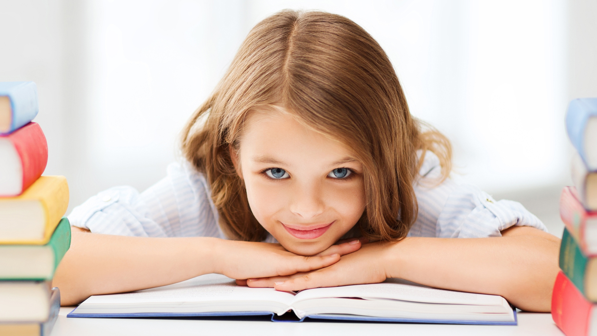 Маленькая голубоглазая девочка школьница с книгой 