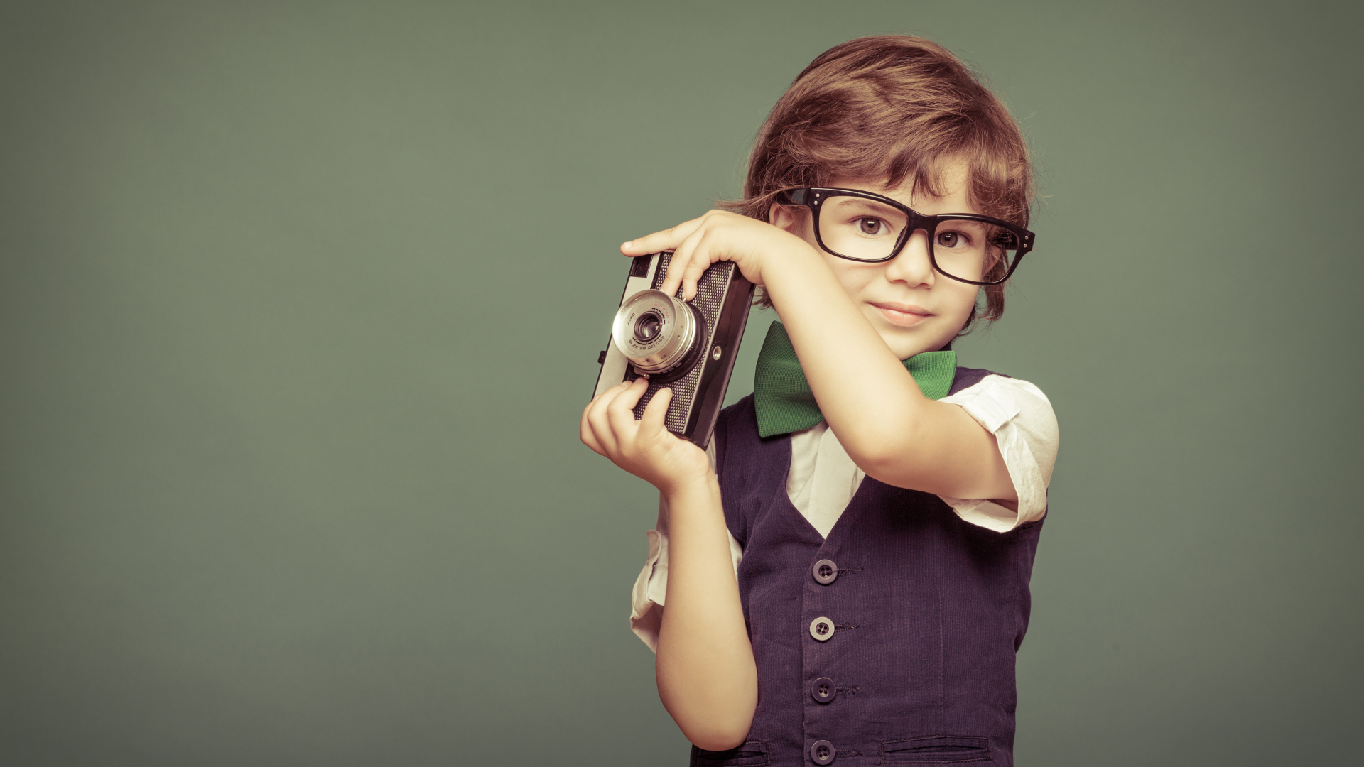 Маленький мальчик в очках с фотоаппаратом