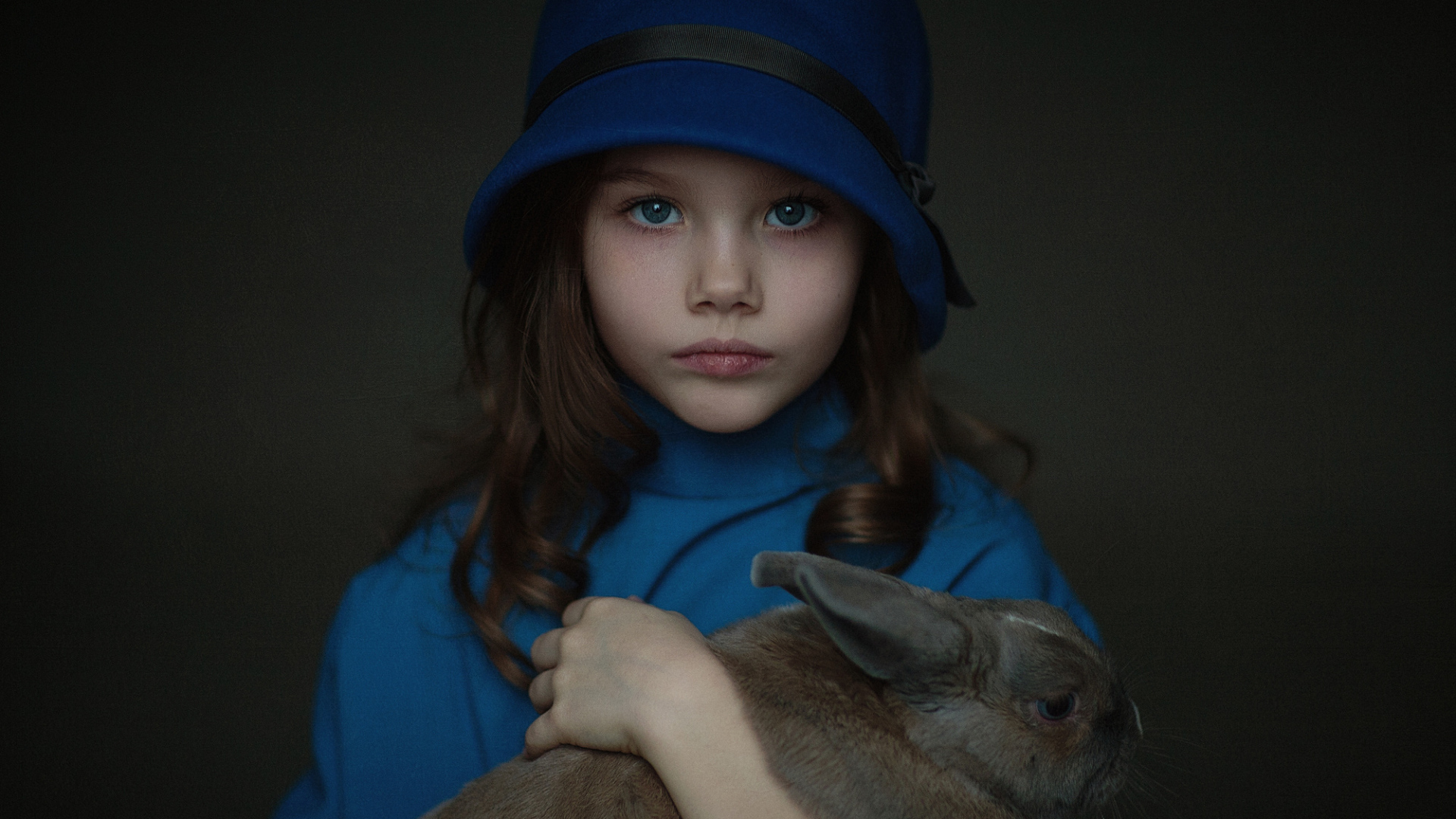 Маленькая девочка в синей шляпе с кроликом