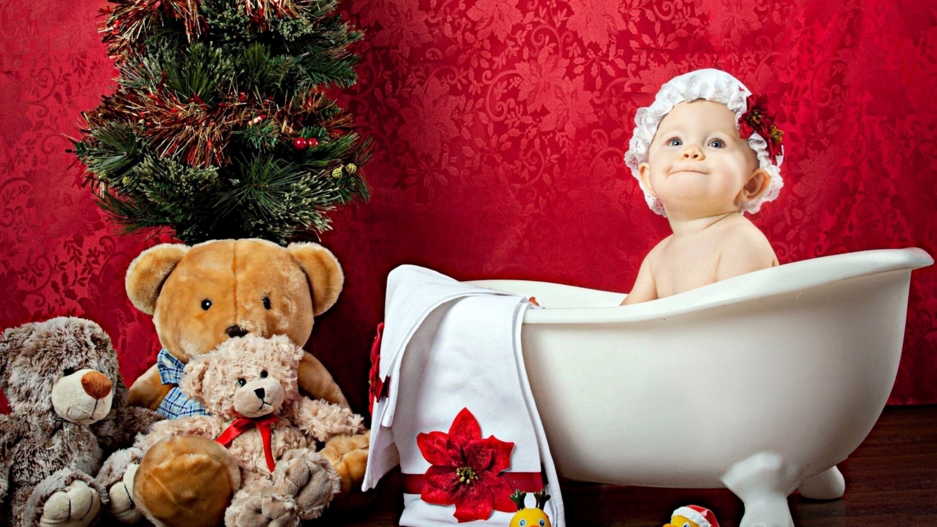 Маленькая девочка сидит в белой ванне у елки с игрушками