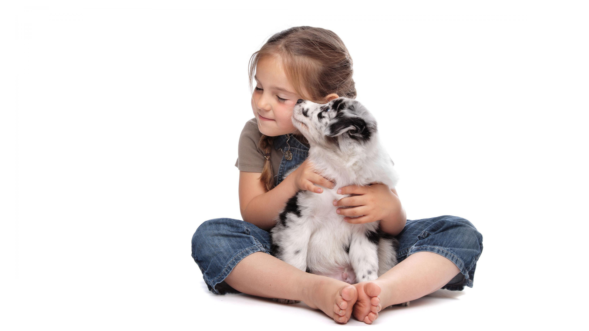 Маленькая девочка с щенком на белом фоне