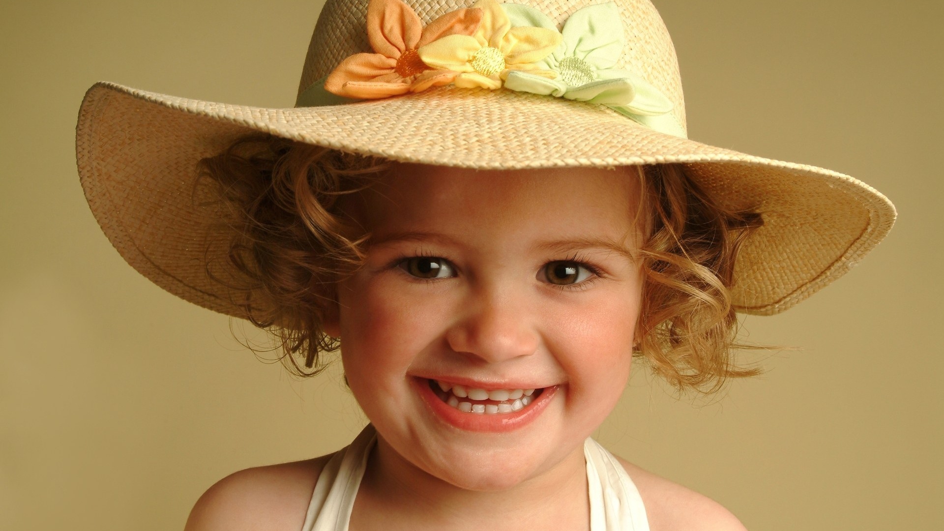 Улыбающаяся девочка в большой шляпе