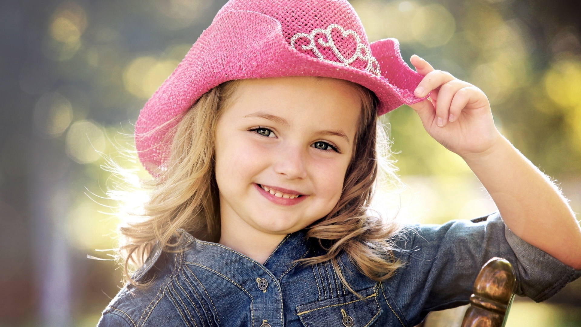 Улыбающаяся девочка в розовой шляпе