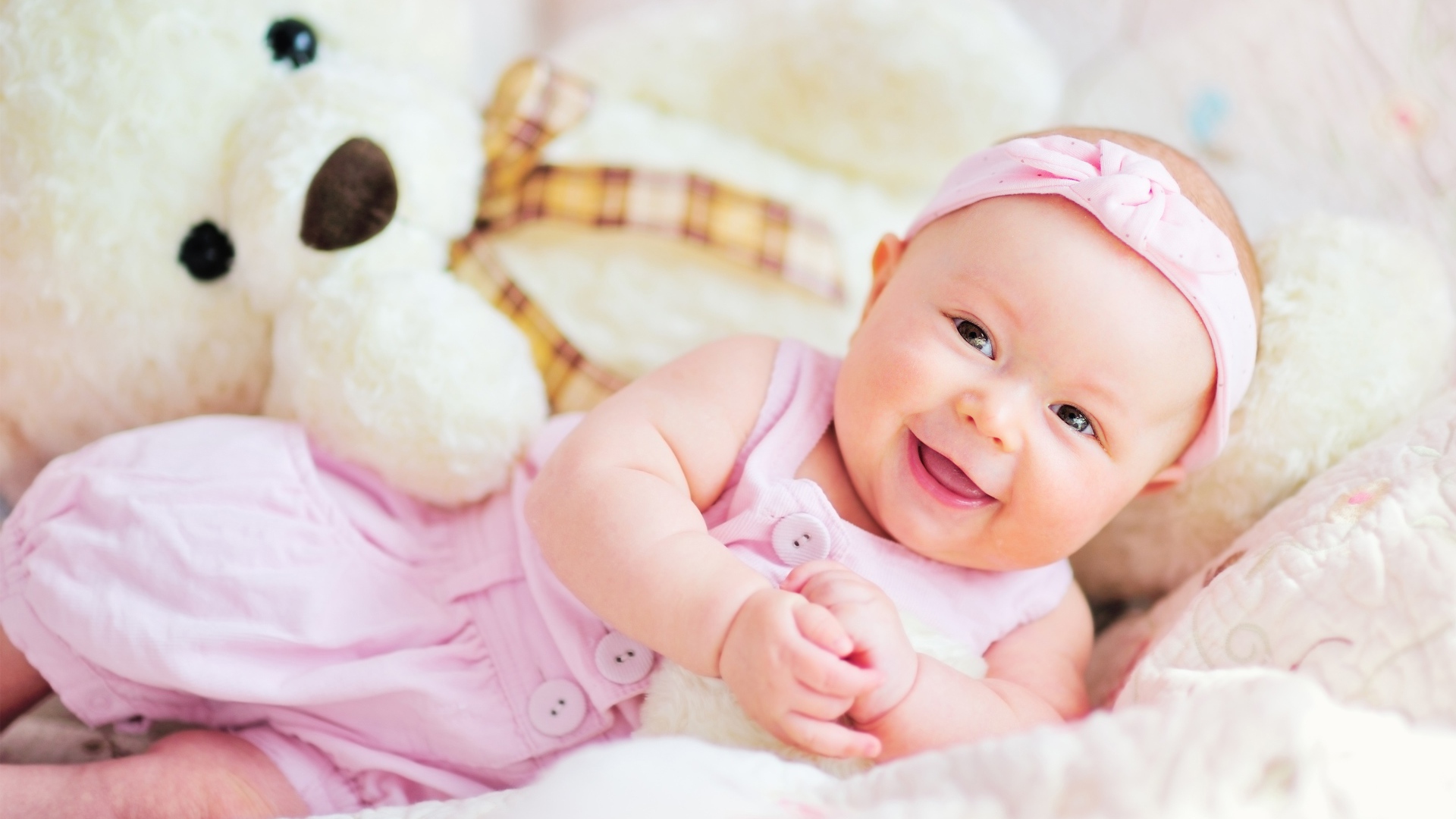 Улыбающаяся маленькая девочка с большим плюшевым медведем