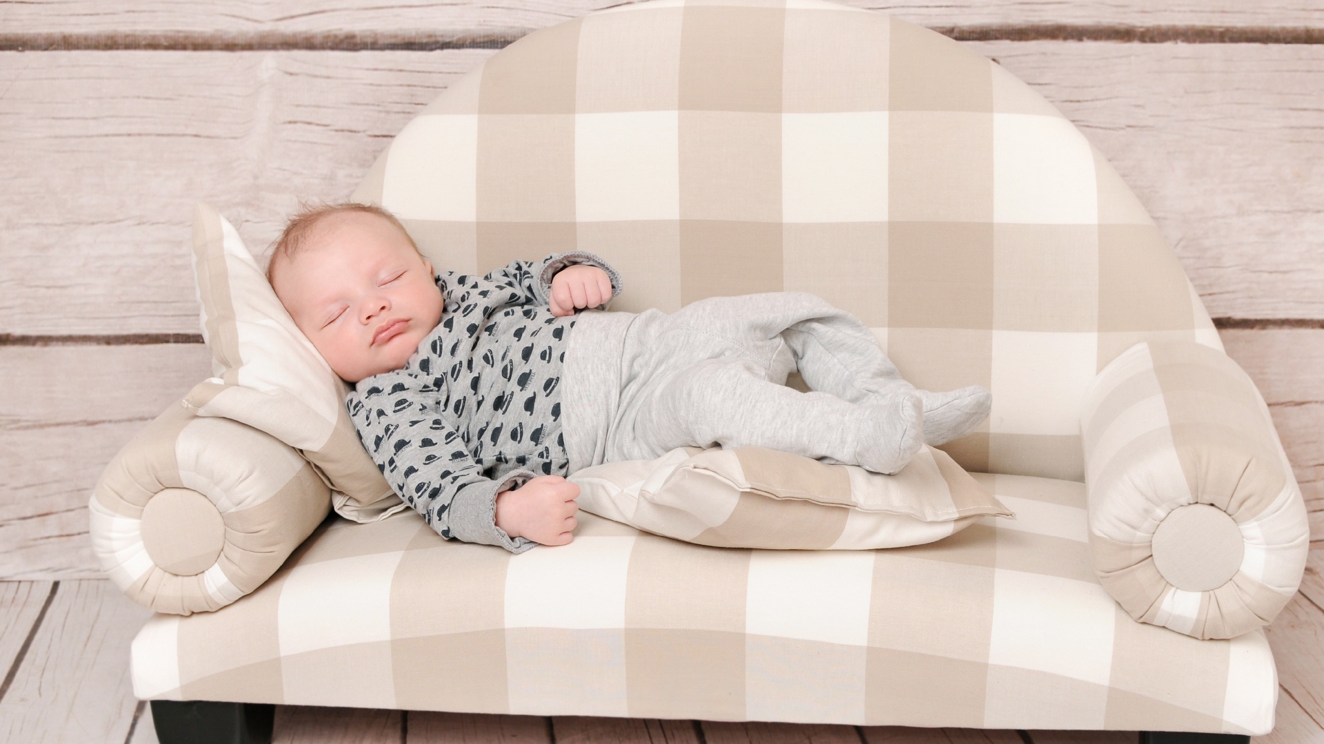 Грудной ребенок спит на диване