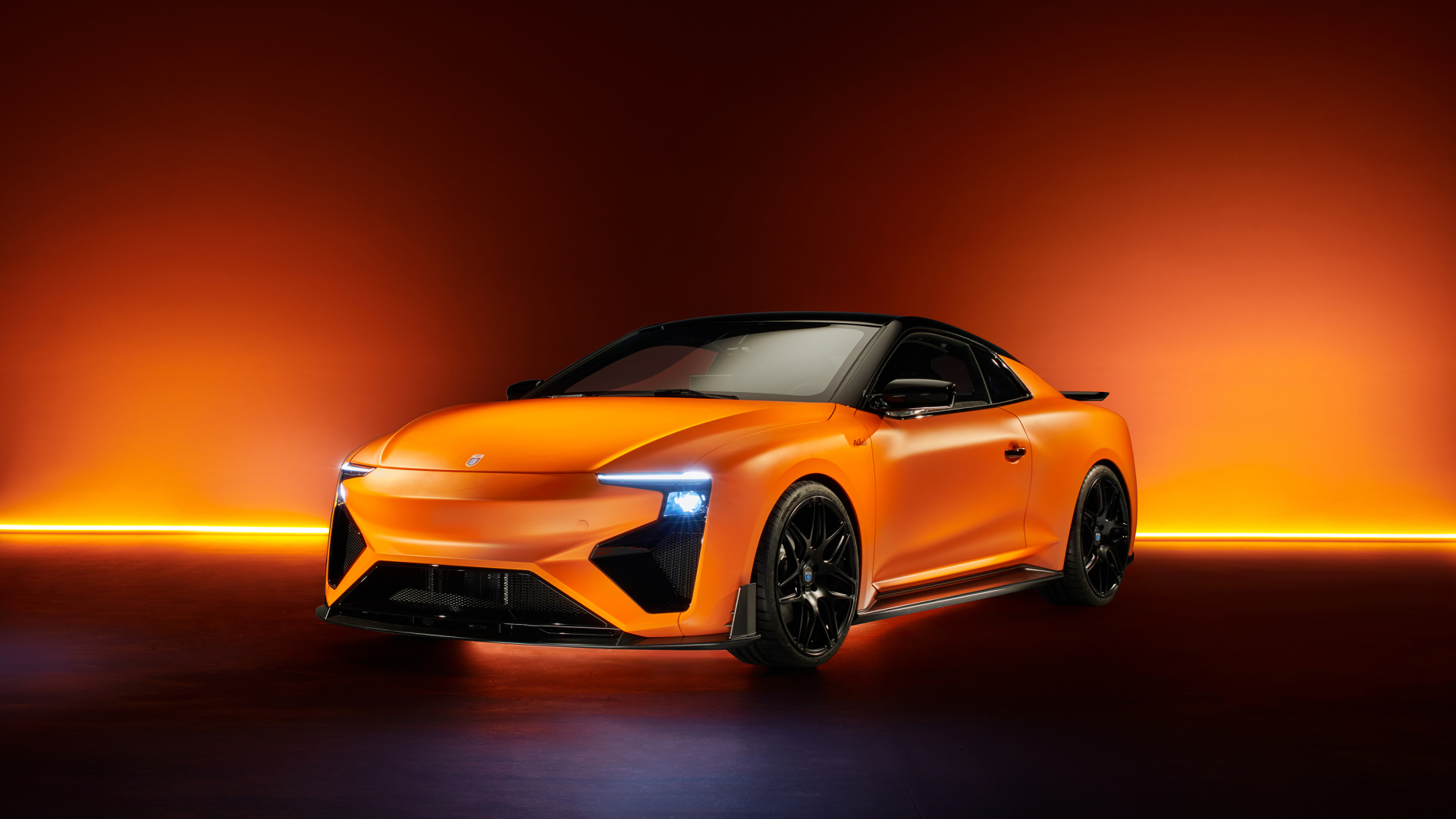Оранжевый автомобиль Gumpert RG Nathalie 2019 года с включенными фарами