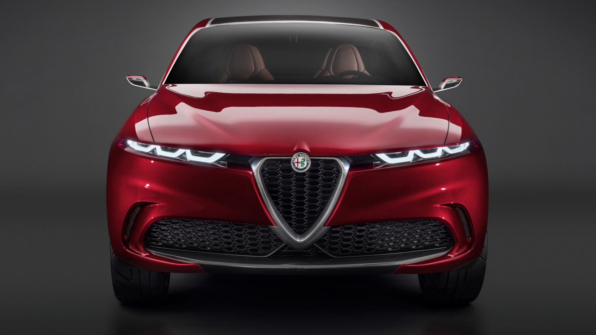 Красный автомобиль Alfa Romeo Tonale Concept,  2019 года вид спереди на сером фоне