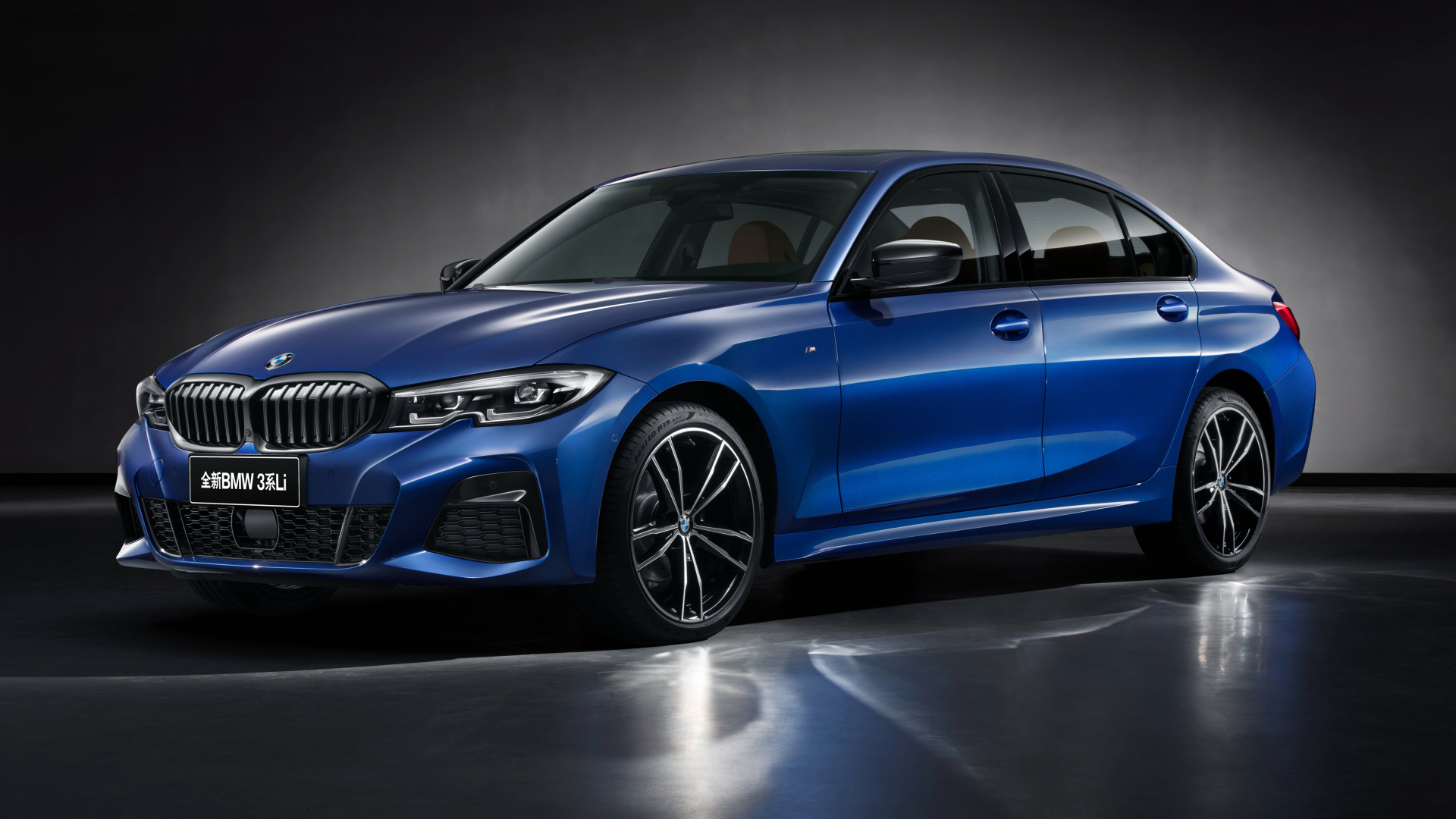 Голубой автомобиль BMW 325Li M Sport 2019 года на сером фоне