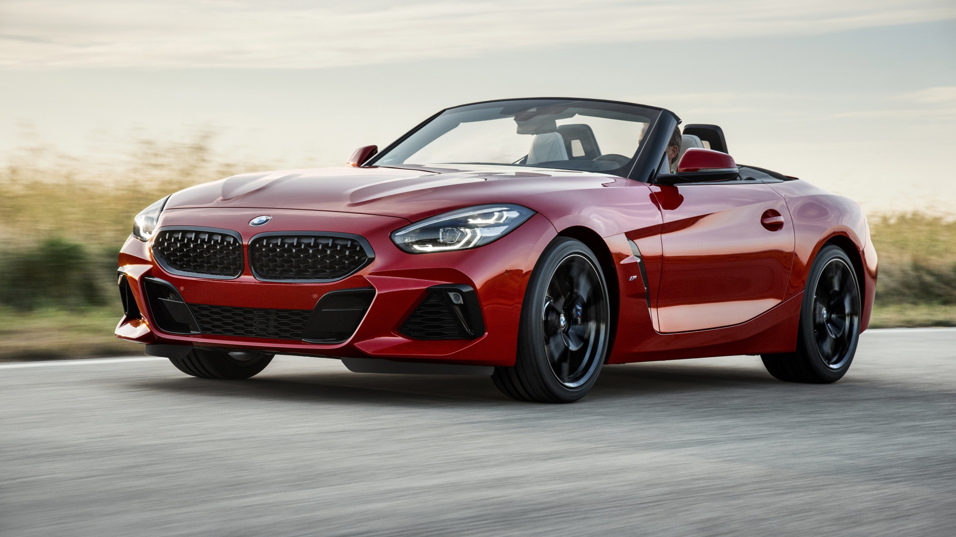 Красный автомобиль кабриолет BMW Z4 на дороге