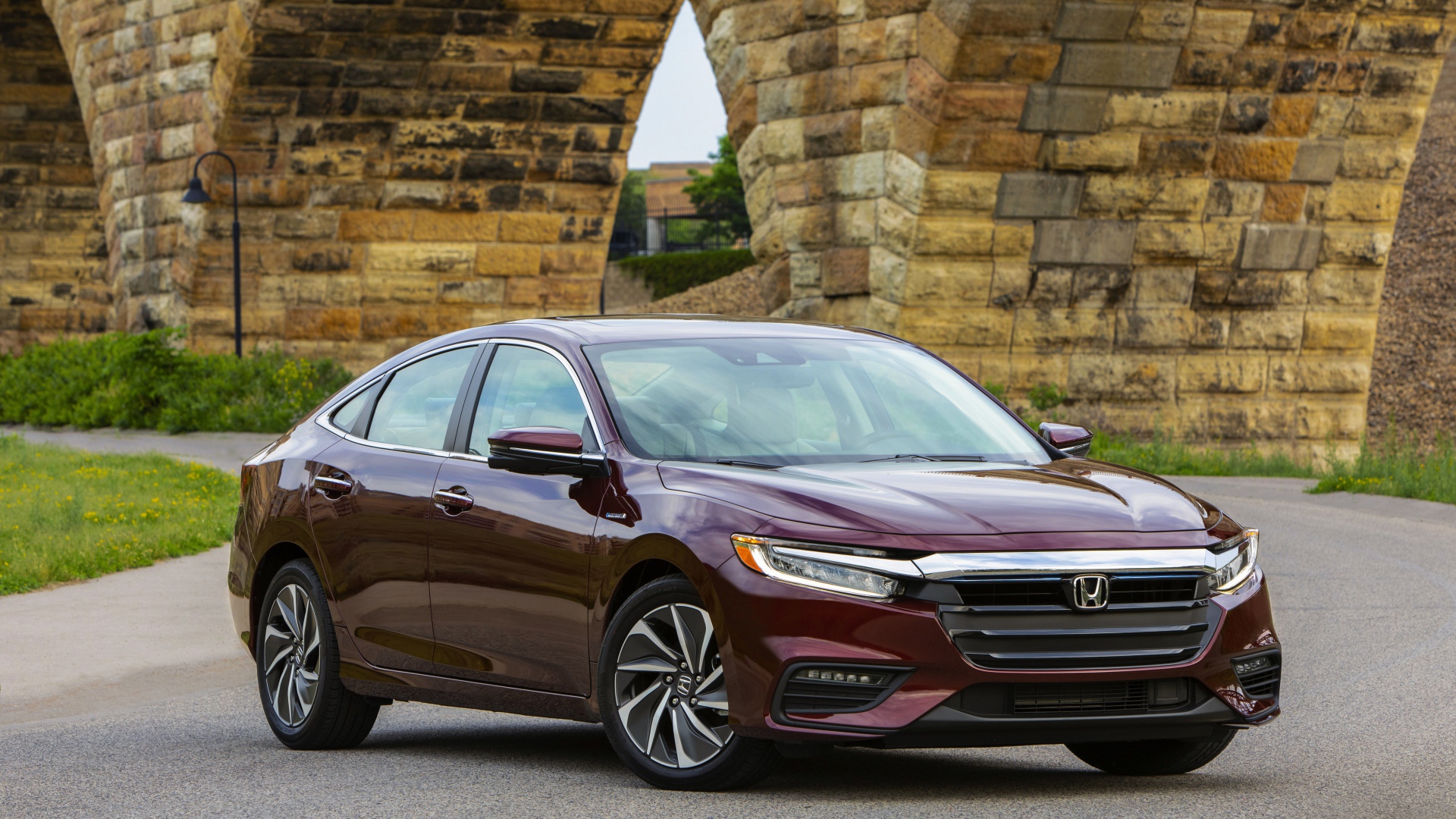 Бордовый автомобиль Honda Insight у моста