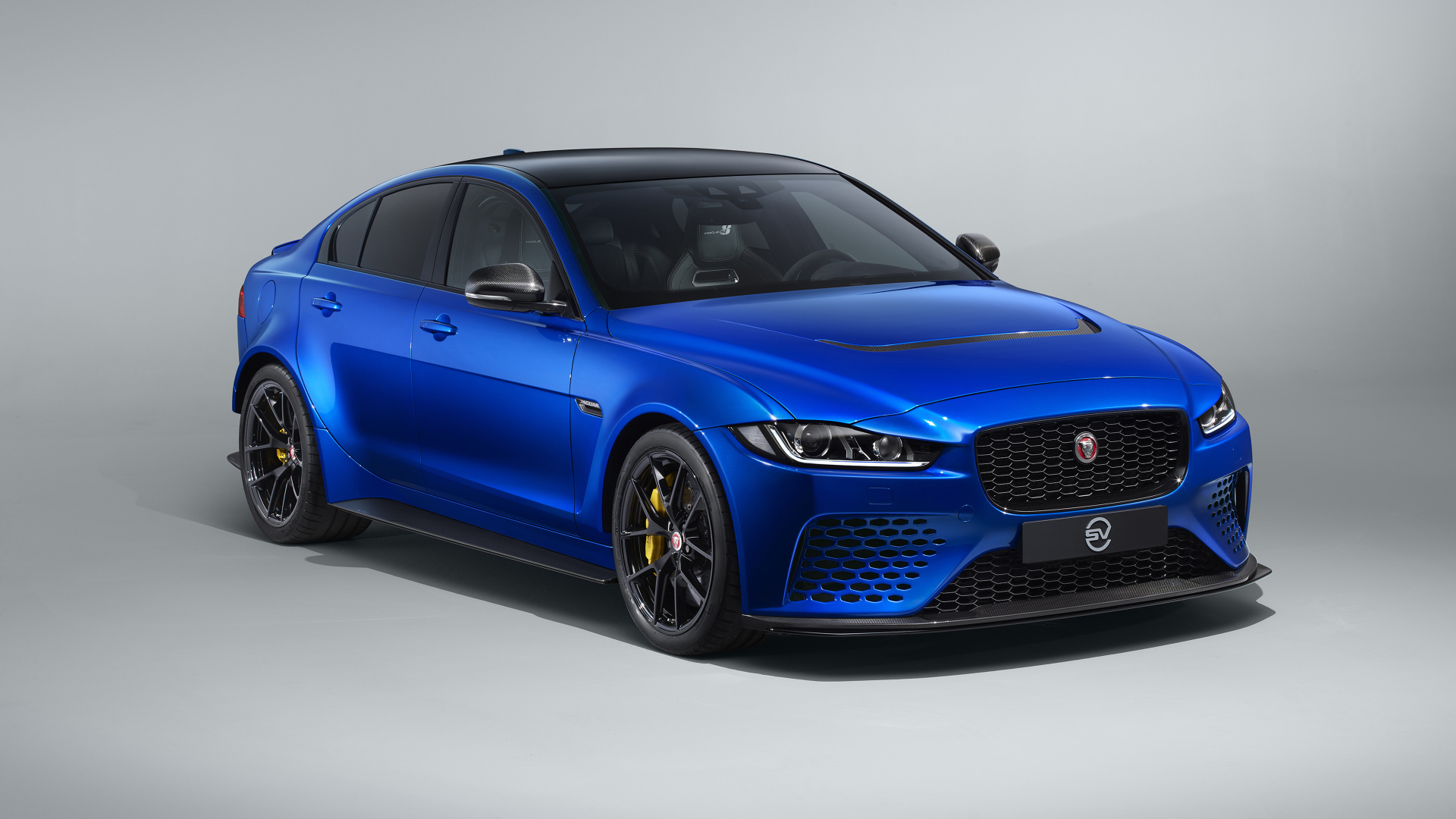 Синий автомобиль Jaguar XE SV Project 8 Touring, 2019 года на сером фоне