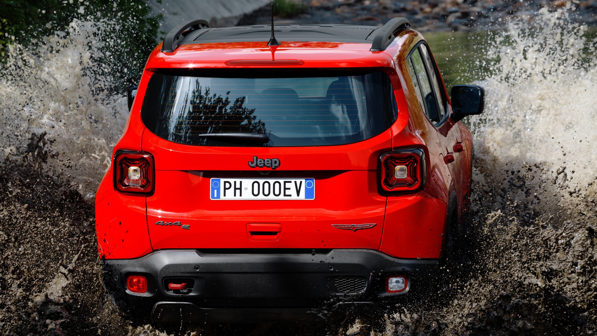 Красный Jeep Renegade Trailhawk Plug-In Hybrid, 2019 года едет по воде вид сзади