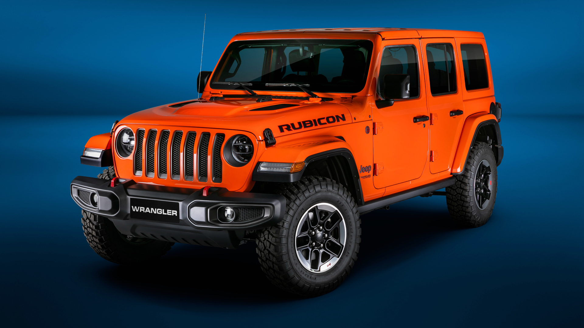 Оранжевый Jeep Wrangler Unlimited Rubicon 2018 года на синем фоне