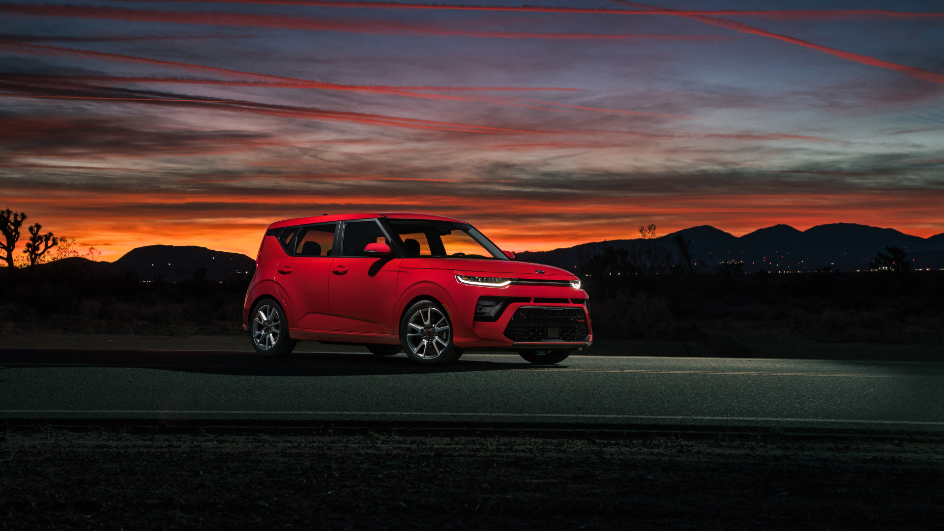 Красный автомобиль Kia Soul GT-Line, 2020 года на фоне ночного неба