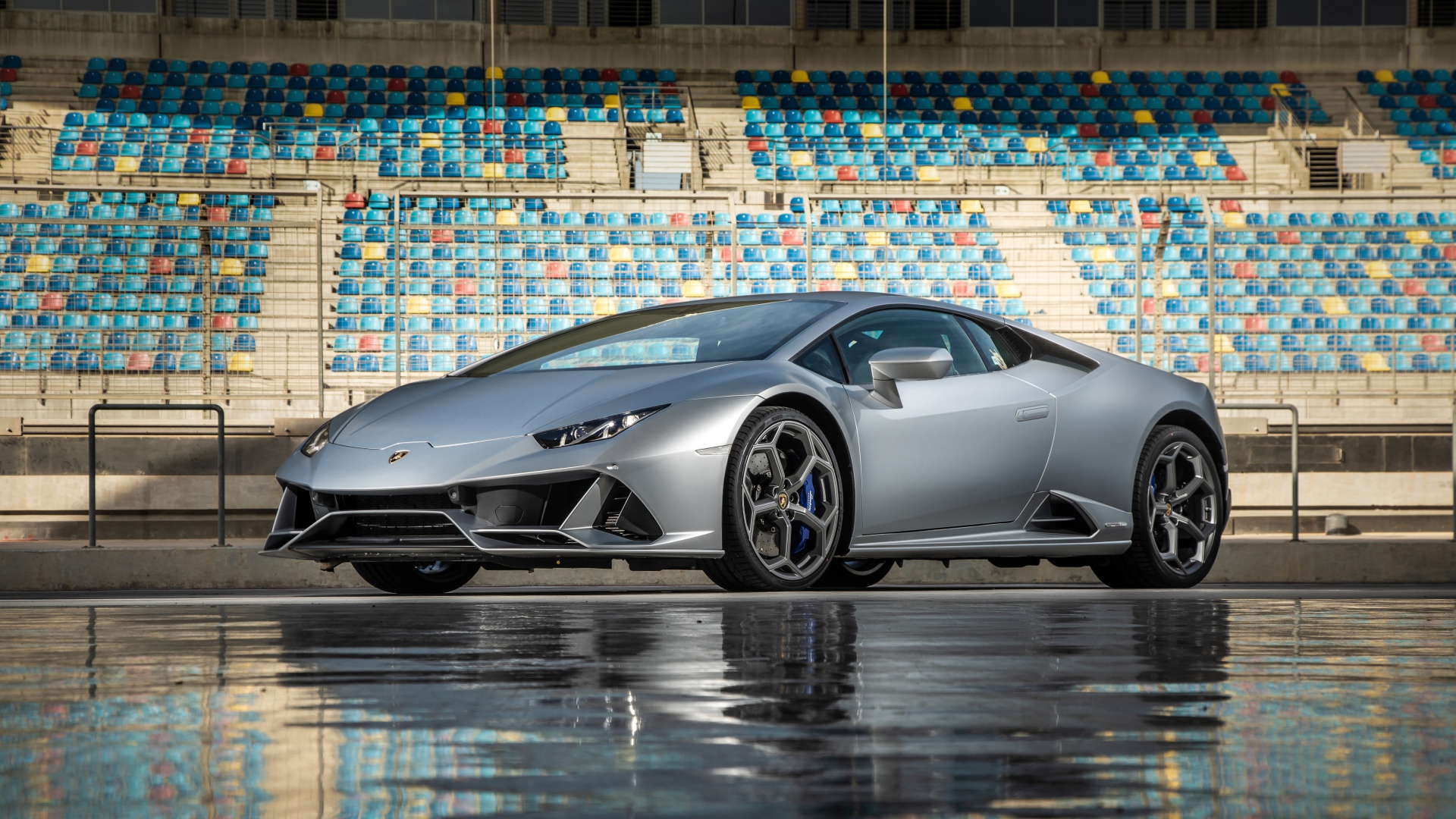 Серебристый автомобиль Lamborghini Huracan Evo на стадионе