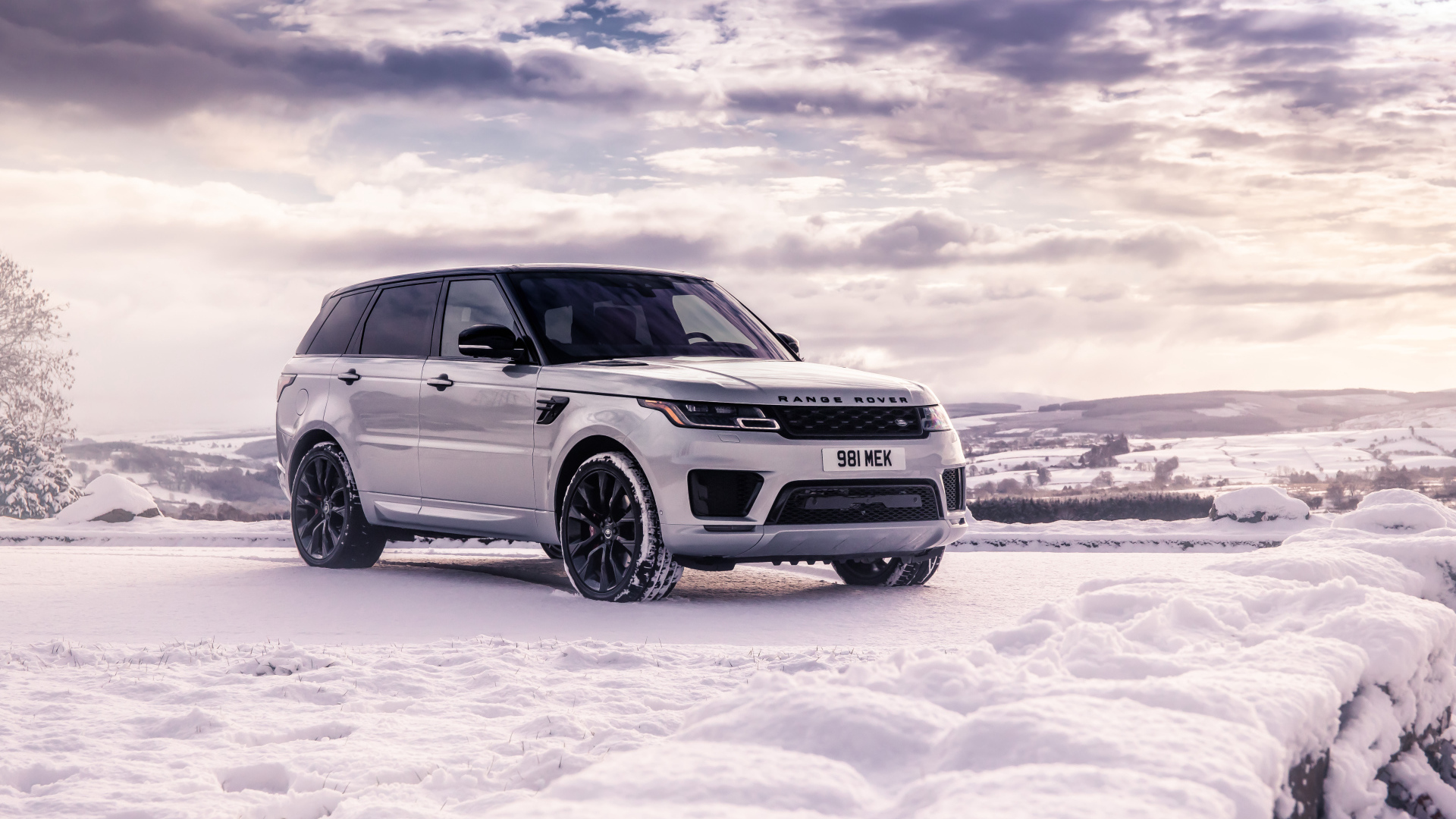Серебристый внедорожник Range Rover Sport стоит на снегу
