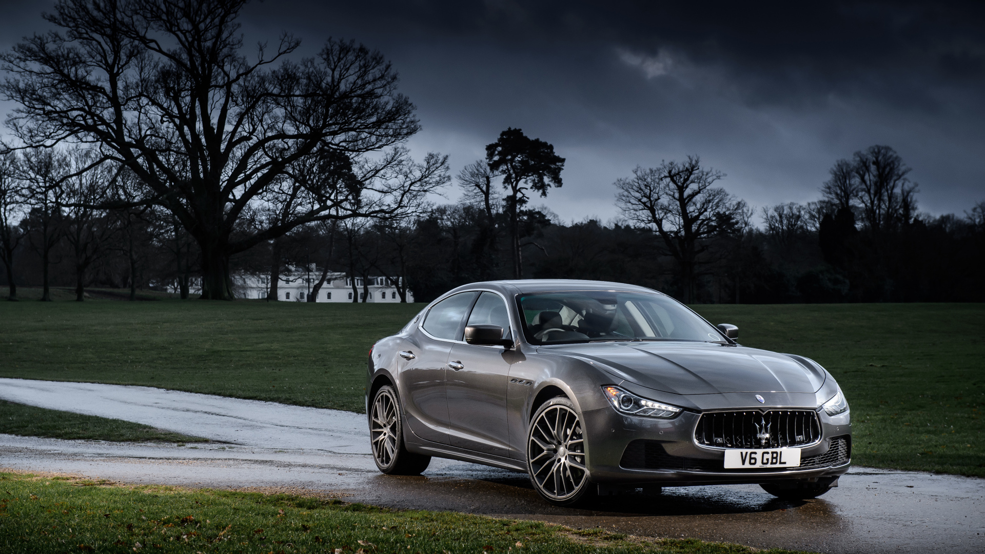 Серебристый автомобиль Maserati Ghibli на фоне грозового неба