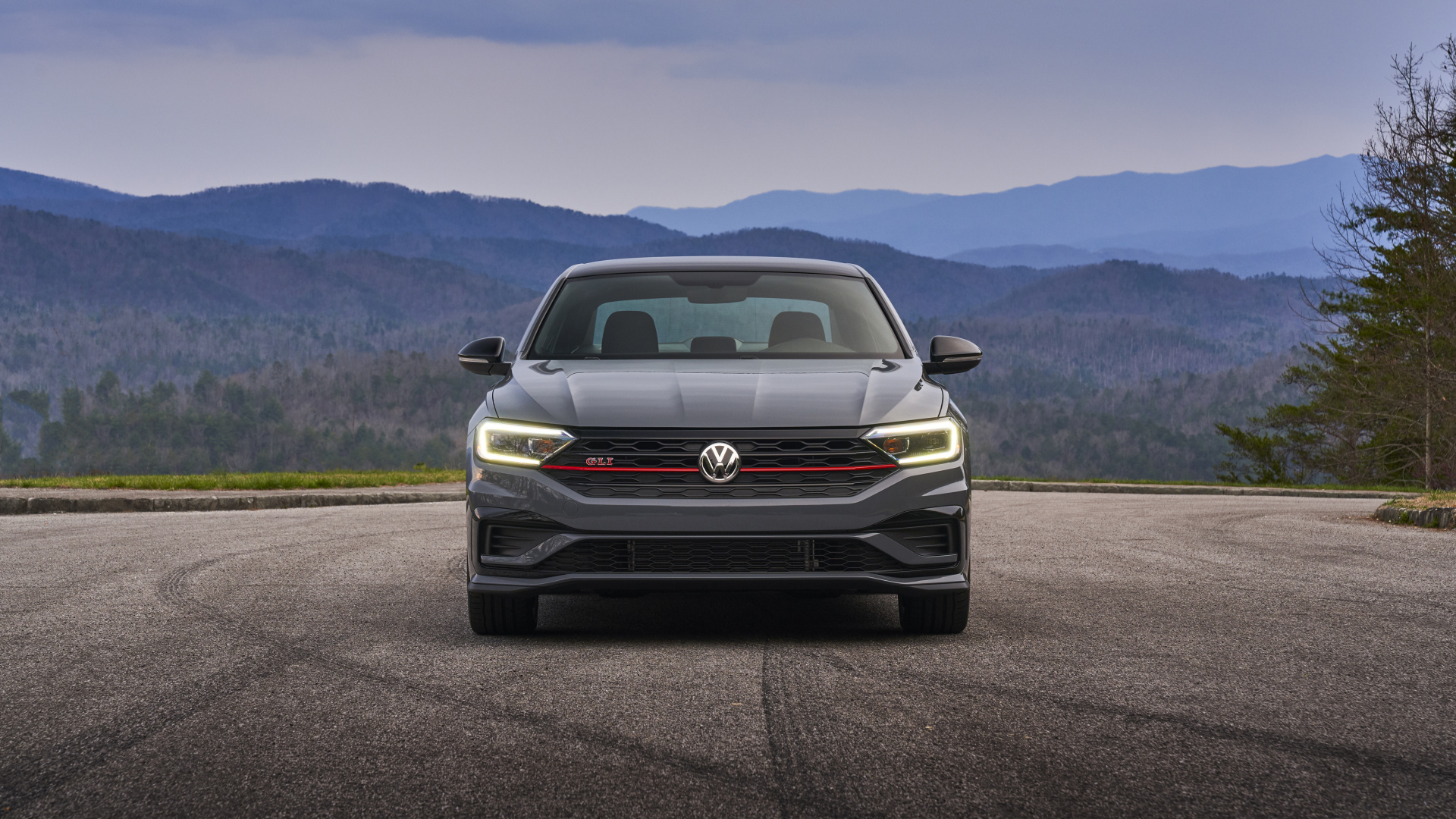 Серебристый автомобиль  Volkswagen Jetta GLI, 2019 года на фоне горизонта 