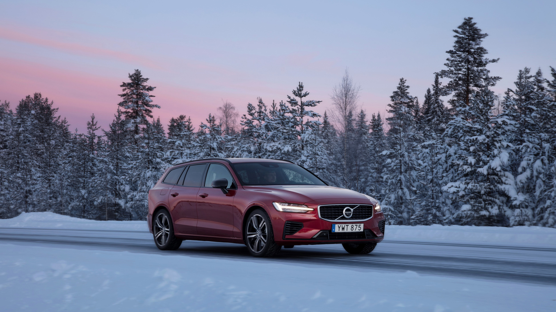 Красный автомобиль Volvo V60 на зимней дороге