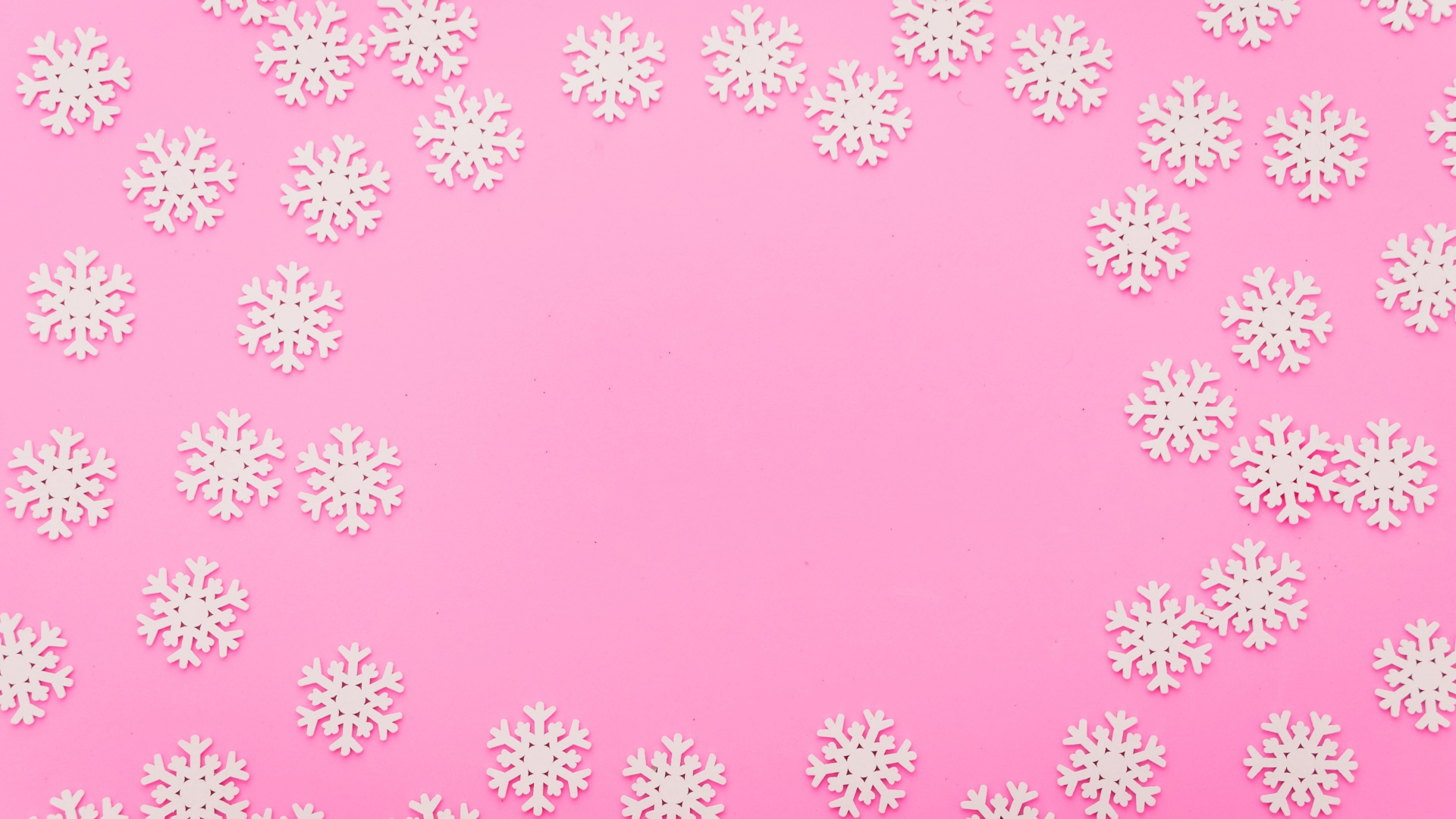 Много белых снежинок на розовом фоне
