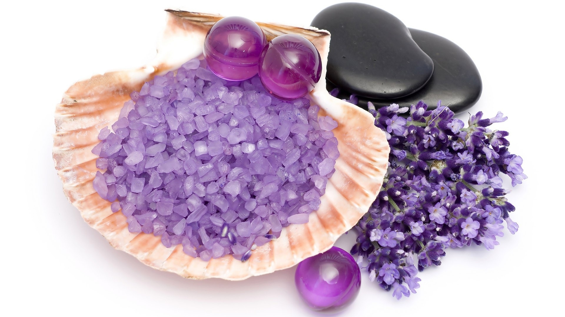 Aromatic salt with balls, lavender flowers and stones on a white background