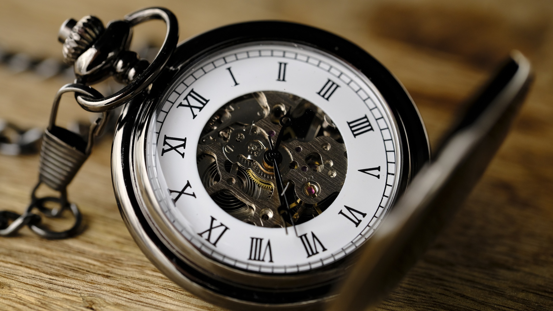 Карманные часы на цепочке на деревянном столе