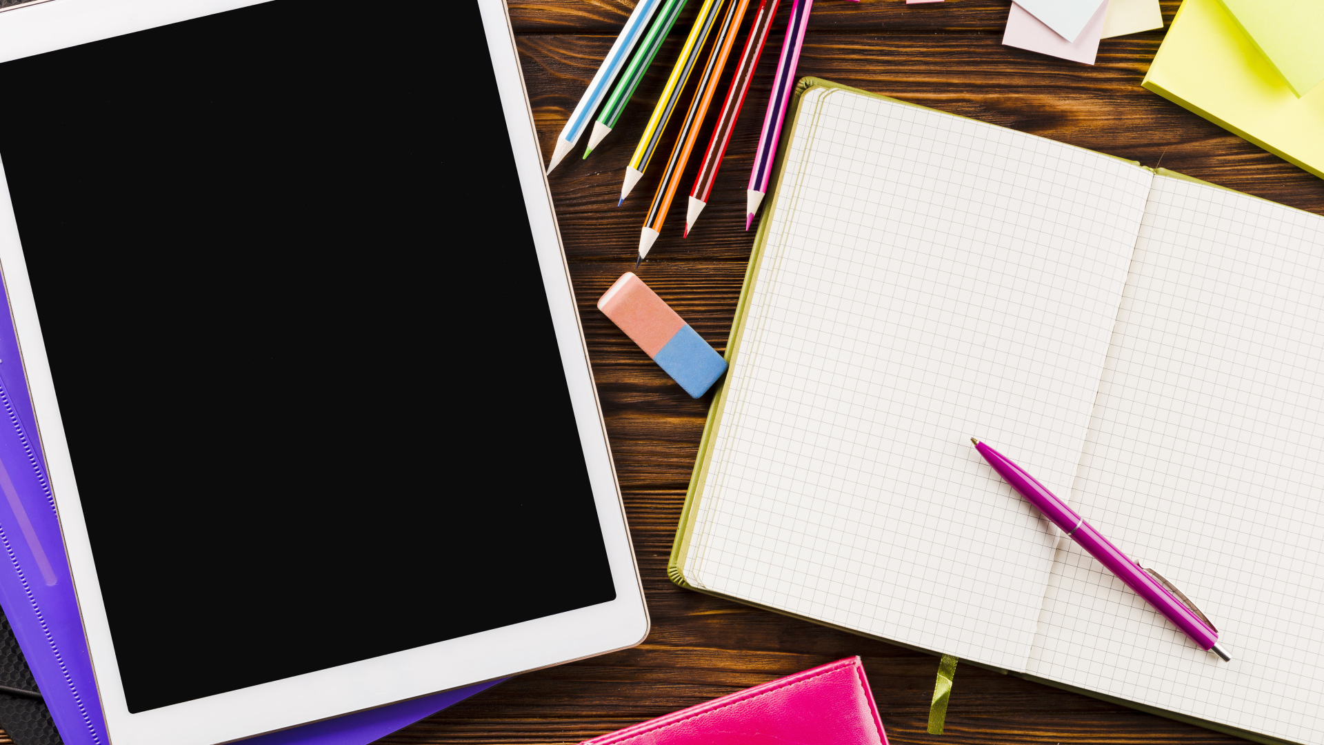 Планшет на столе с блокнотом и карандашами