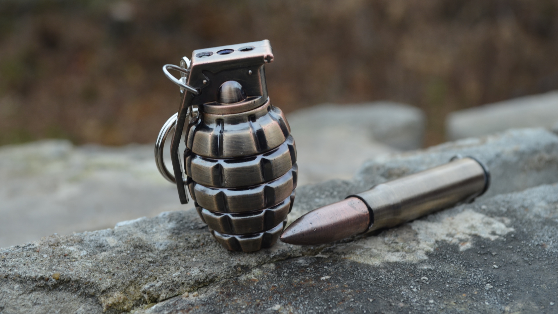 Боевая граната с патроном лежат на камне 