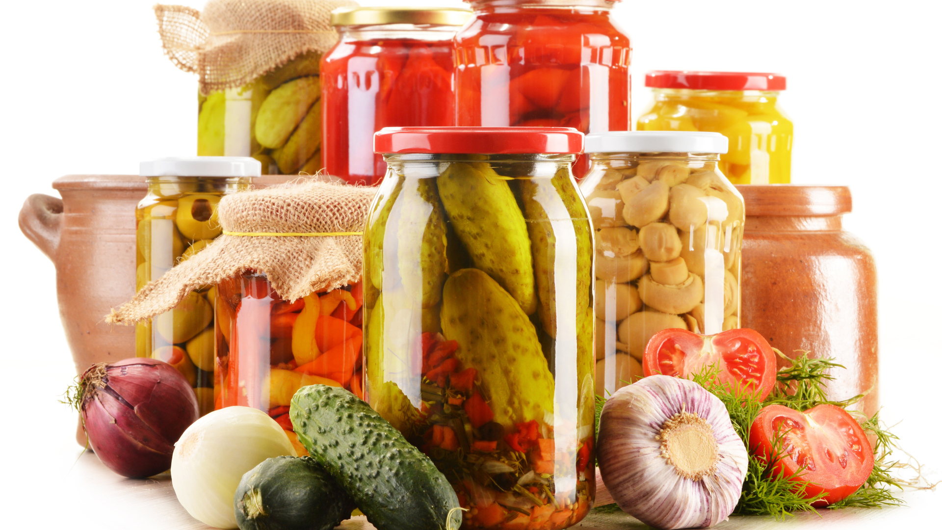 Консервация в банках на белом фоне с овощами