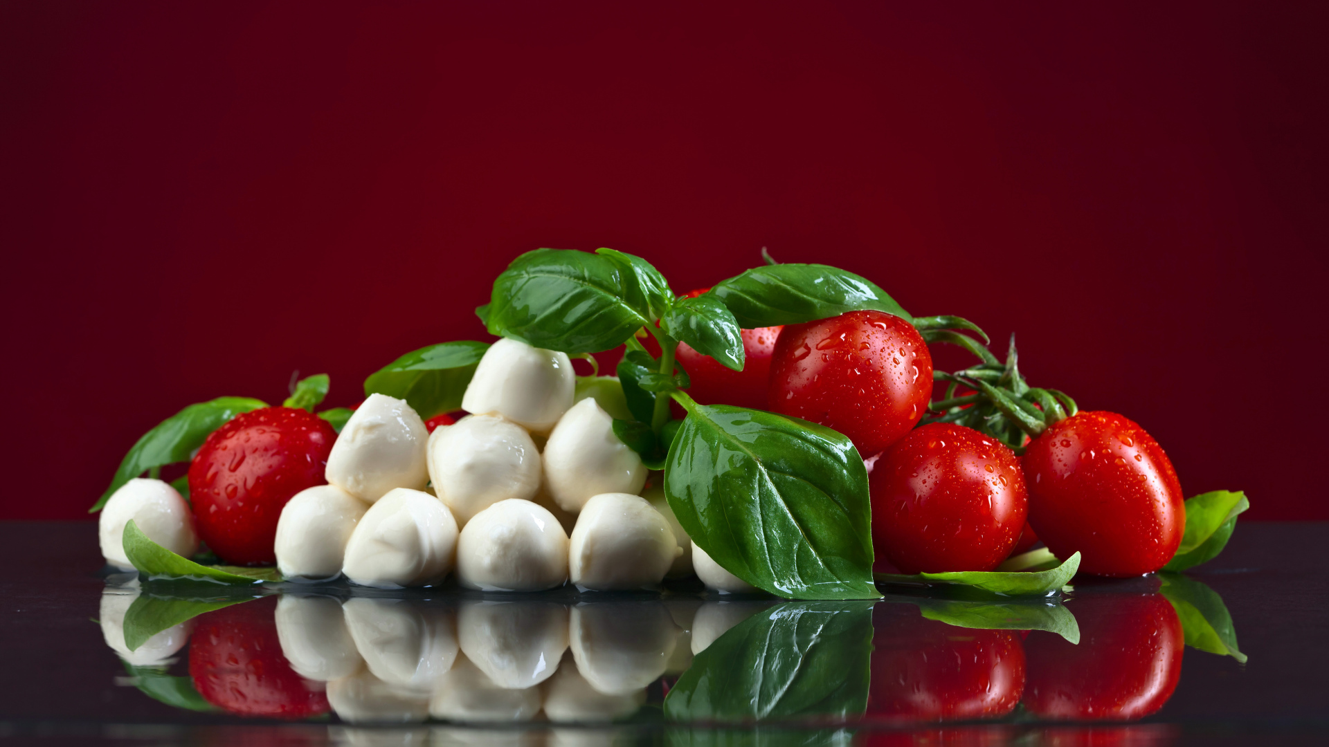 Сыр на столе с зеленью базилика и красными помидорами