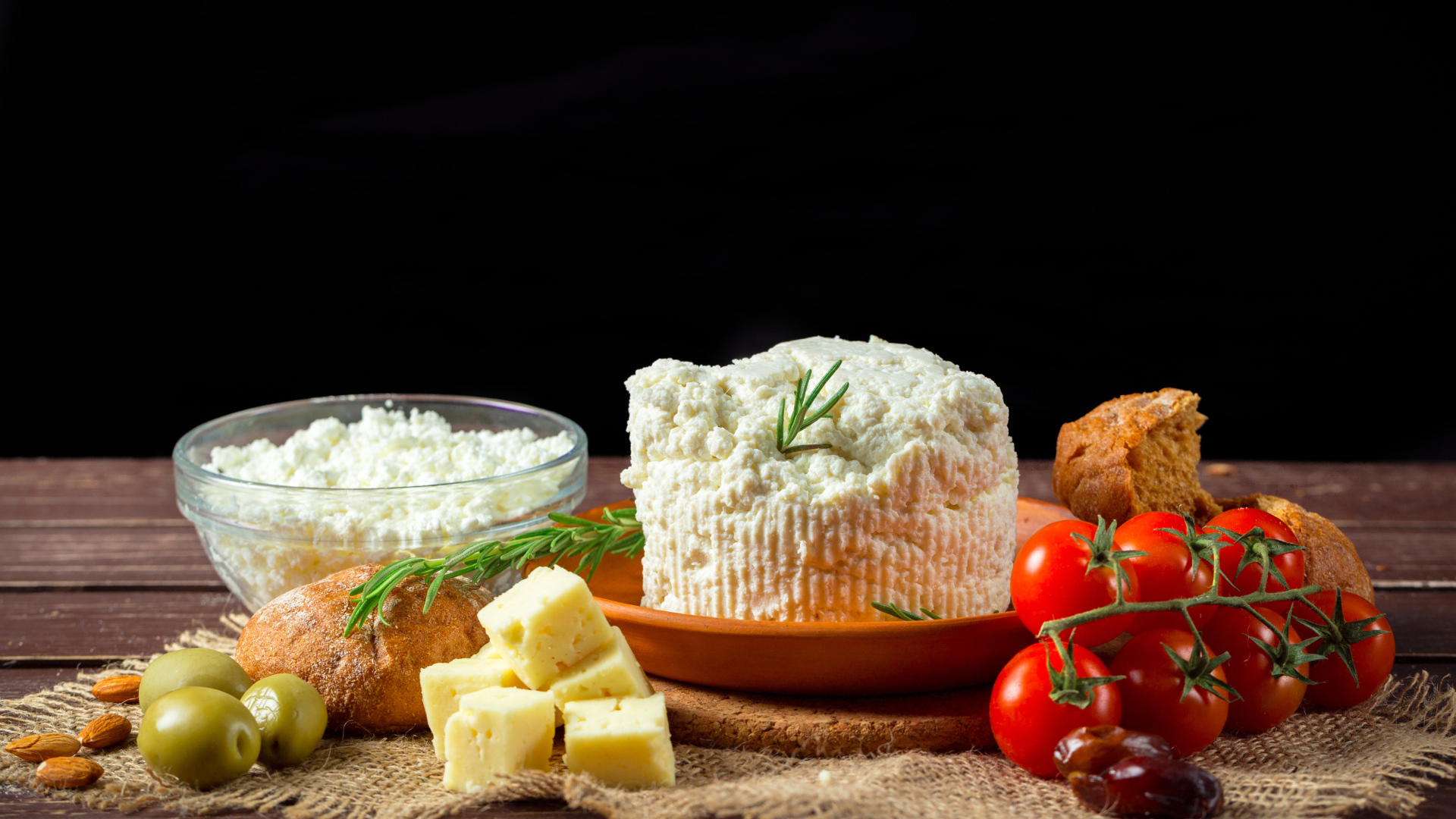 Творог на столе с сыром, хлебом и помидорами