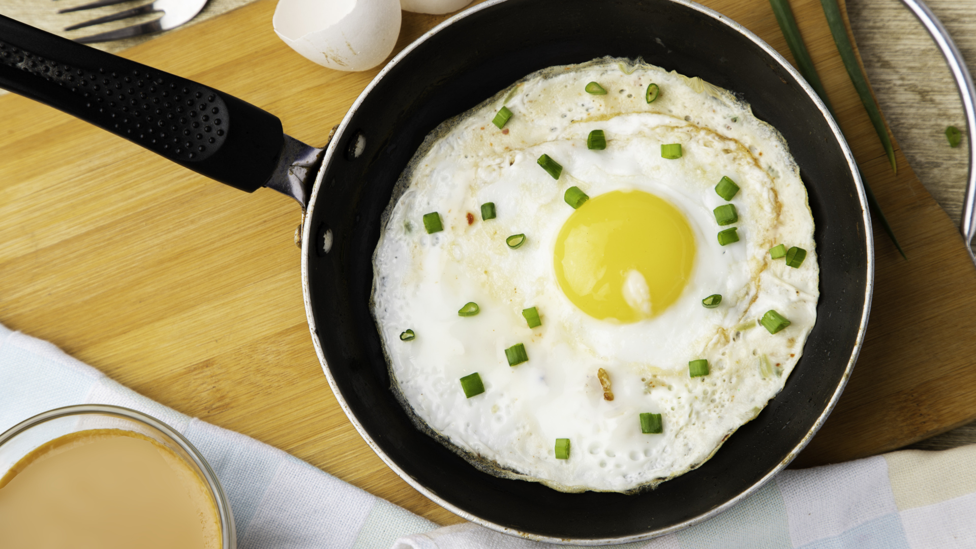 Яичница глазунья на сковороде с зеленым луком