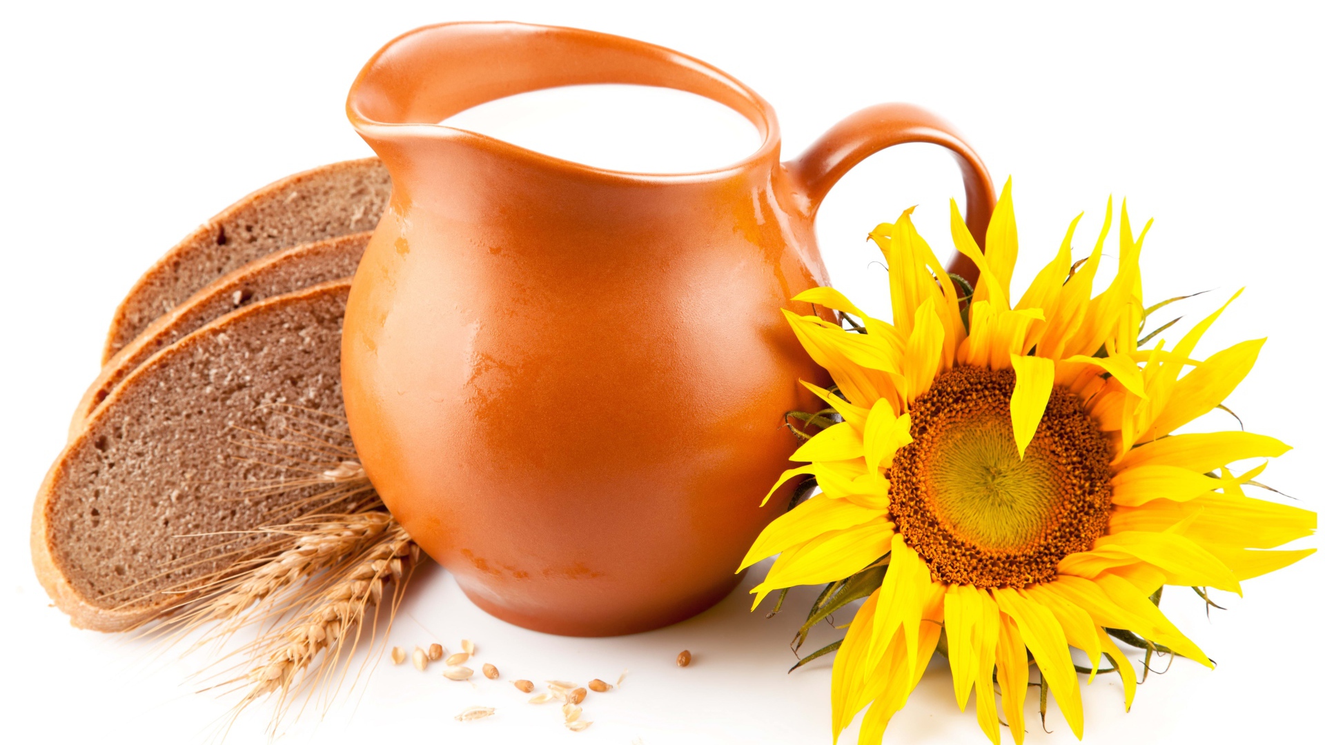 Кувшин с молоком на белом фоне с хлебом и подсолнухом