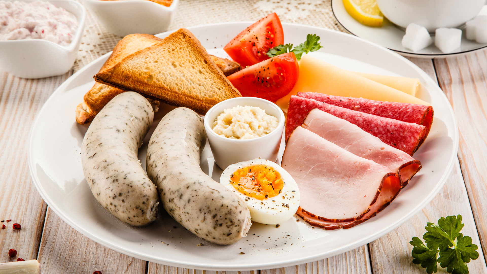 Large white plate with sausage, eggs, tomatoes, toast and cheese