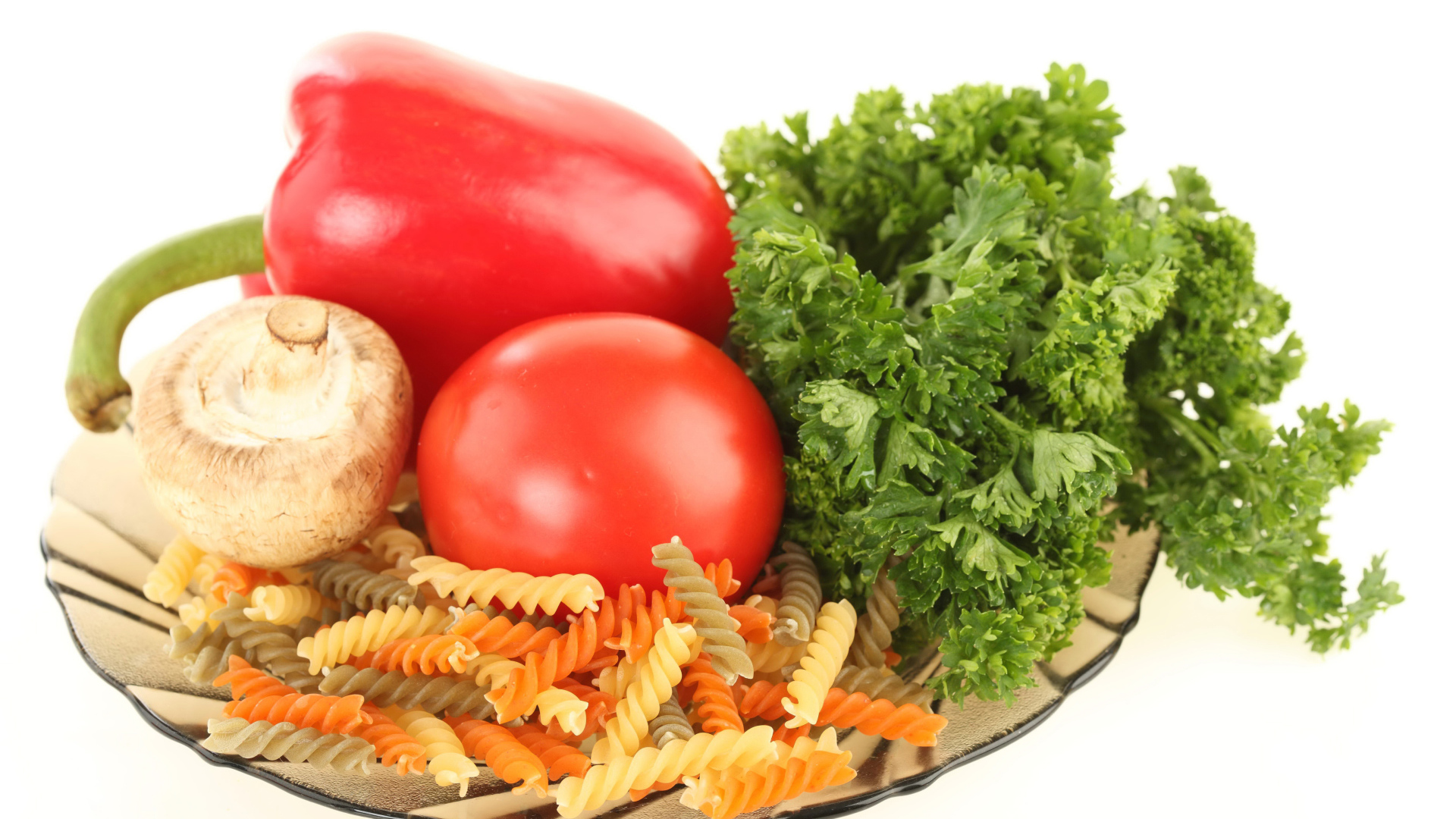 Тарелка с макаронами, красным перцем, помидором, шампиньоном и зеленью петрушки