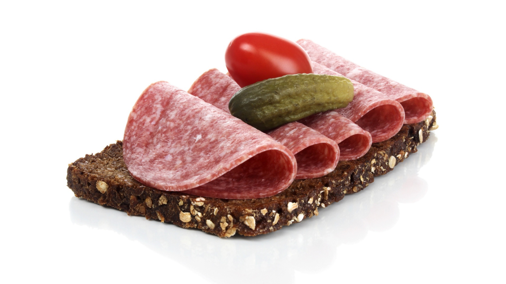 Бутерброд с черным хлебом, колбасой, соленым огурцом и помидором на белом фоне