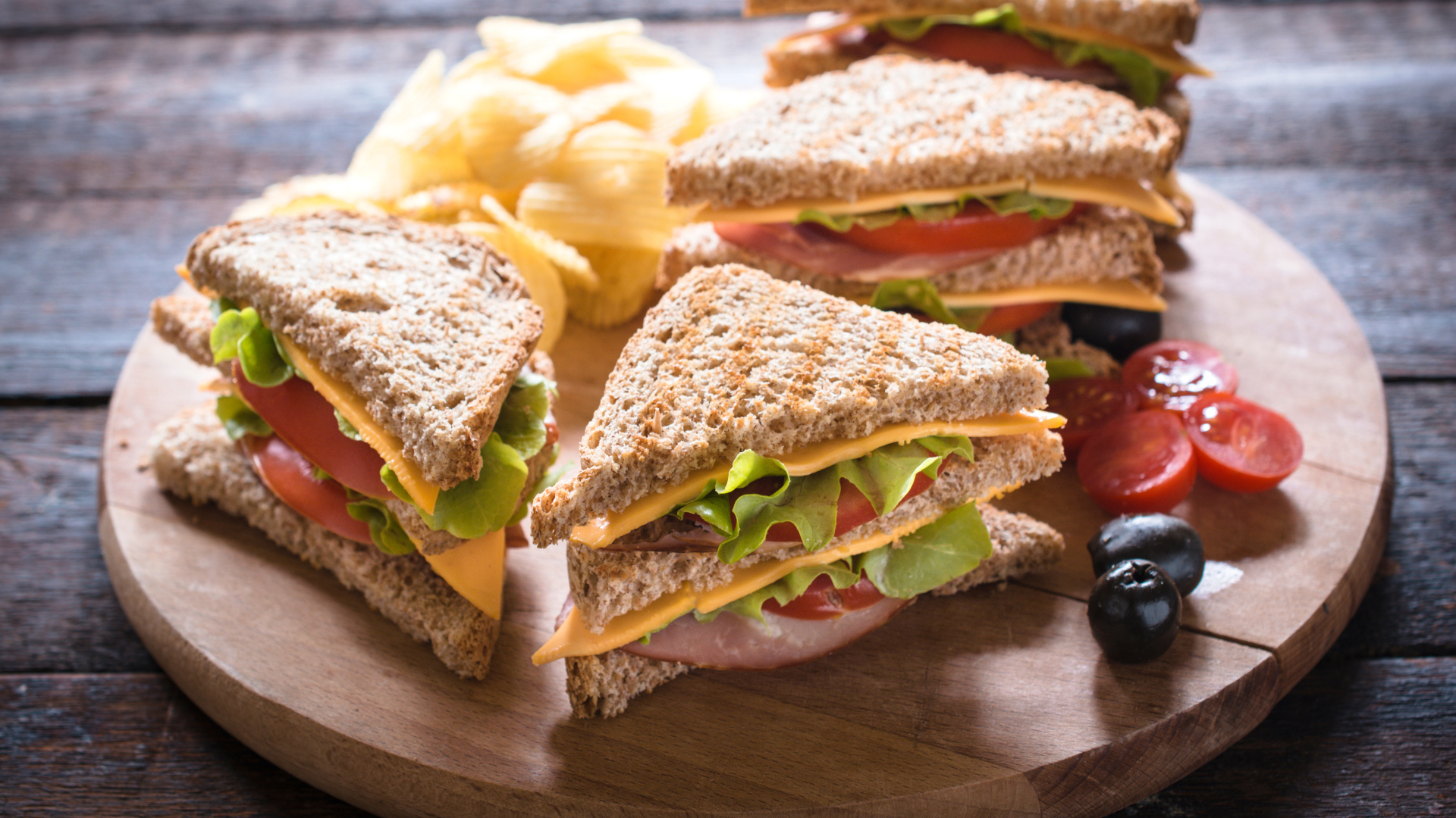 Сэндвичи на деревянной доске с оливками