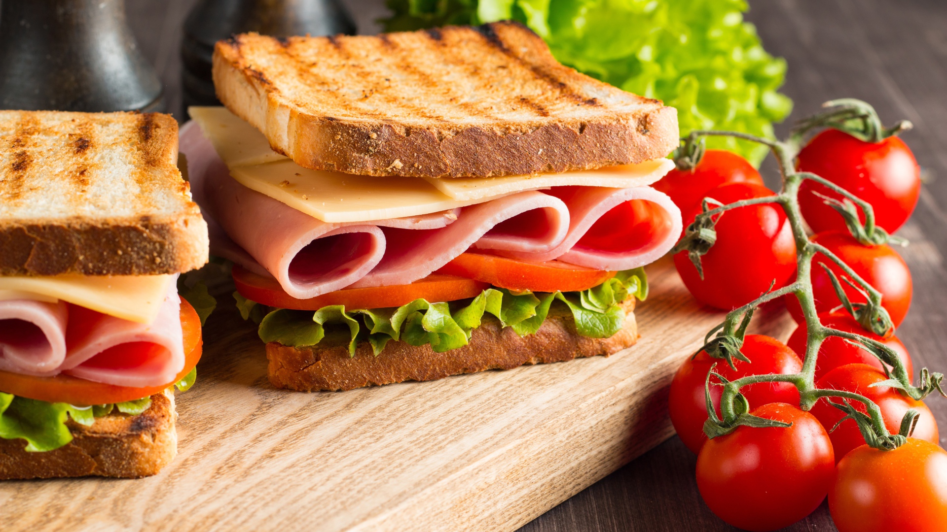 Бутерброды на столе с помидорами и листьями салата