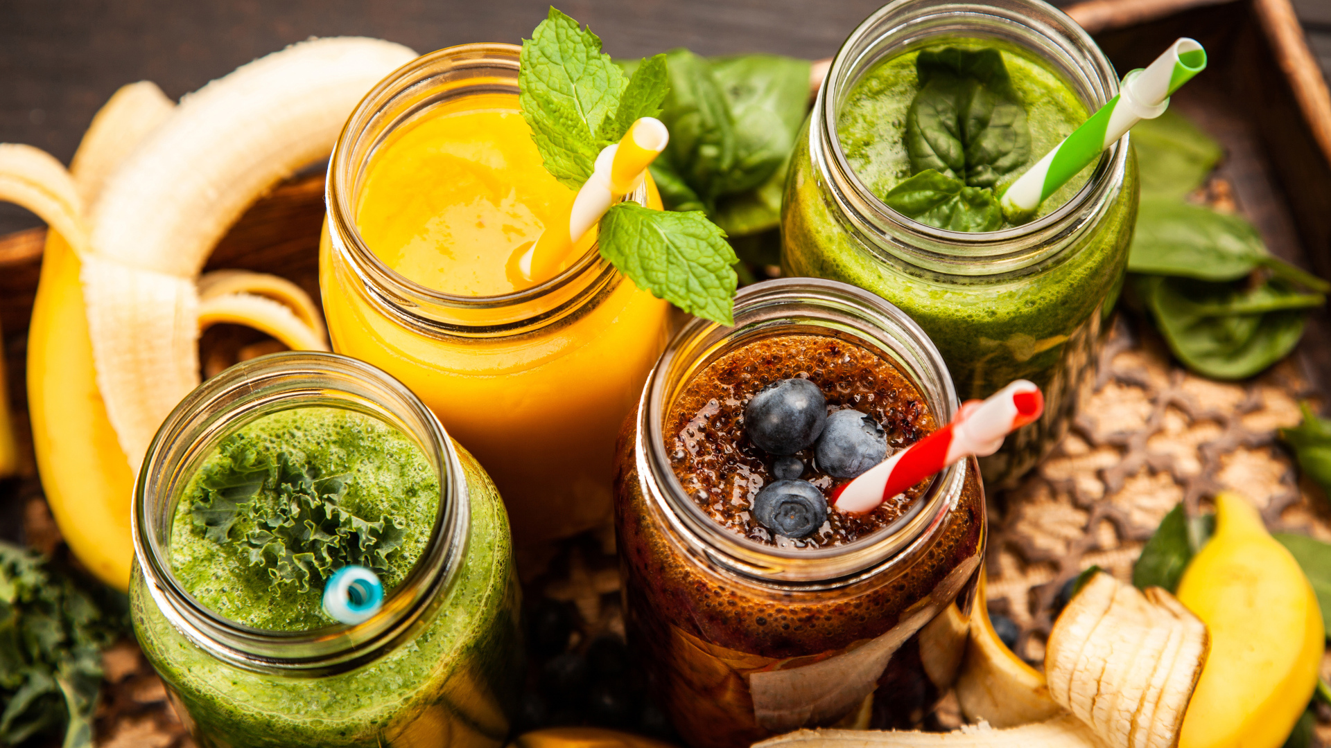Банки со смузи на столе с бананами