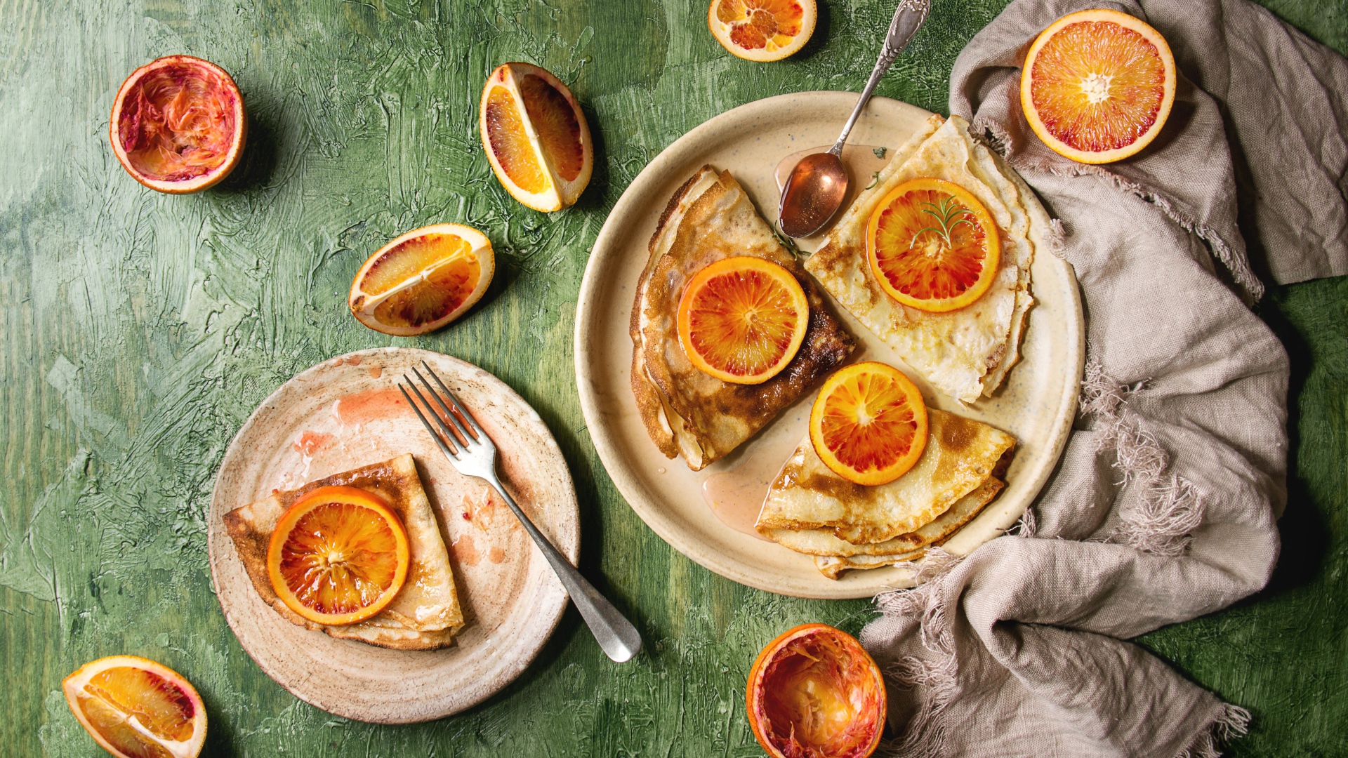 Тонкие блинчики с апельсинами на столе