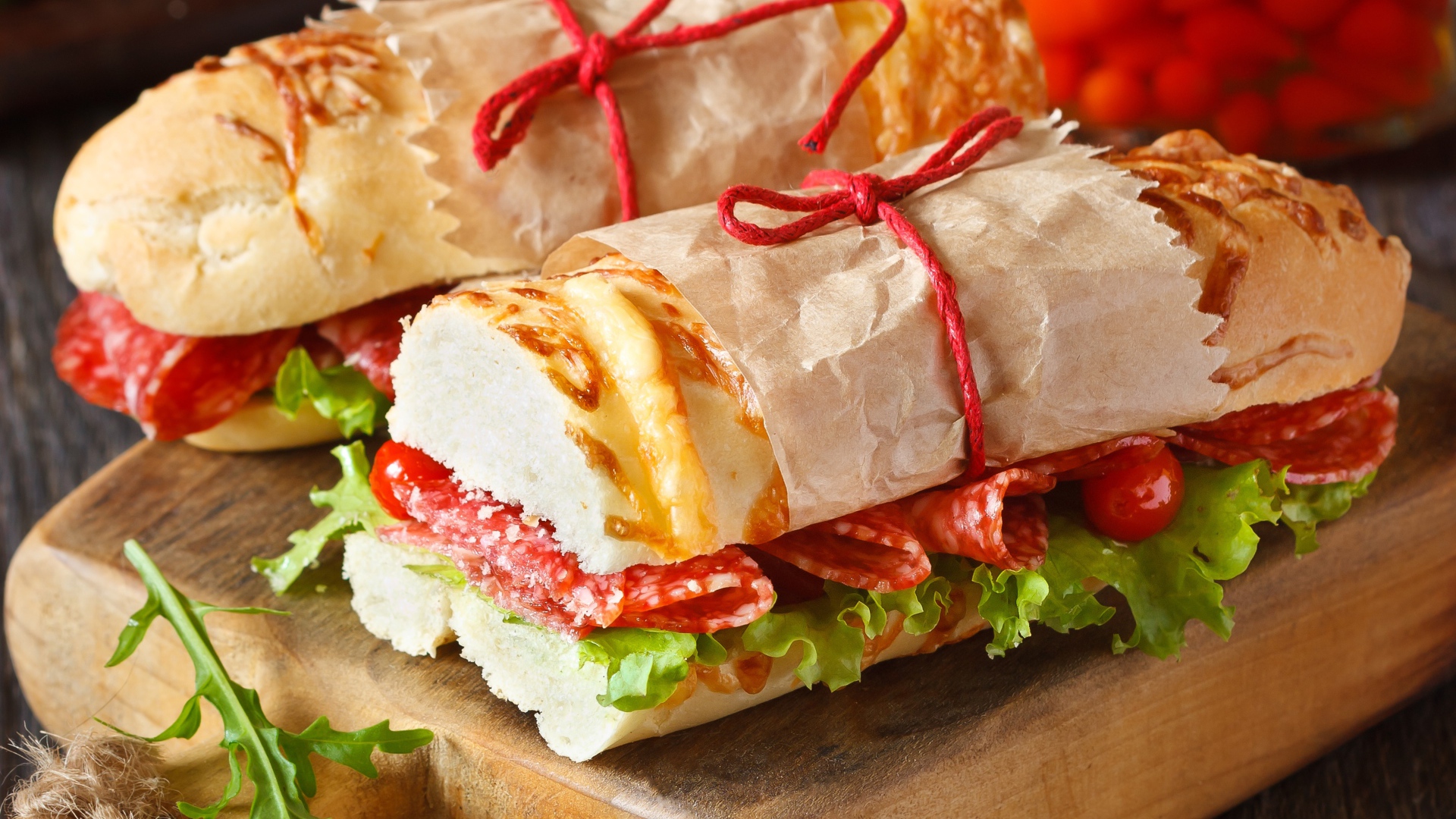 Два огромных бутерброда с колбасой и листьями салата